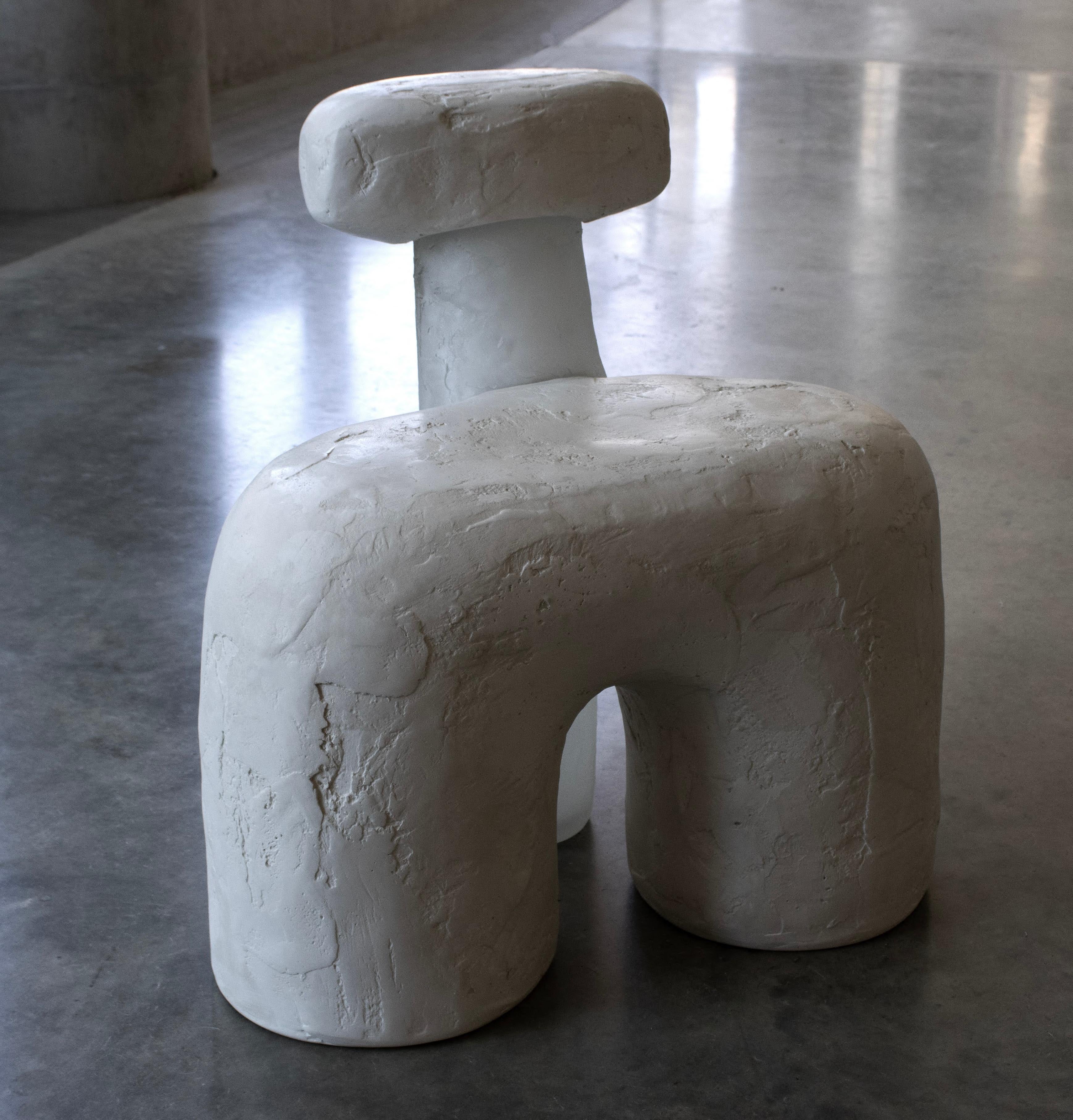 The Marrow Chair is a three-legged side chair. Monolithic in it's weighted stance, the materials of glass in hydrocal act in tandem with each other rather than in contrast, to oscillate in and out of opacity and presence. The spackle texture of both