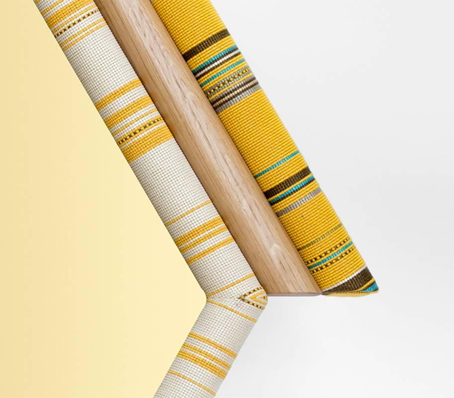 Pontiac mirrors are inspired by American Indian tribes. Hexagon version has vibrant colors combined with American white oak and golden tinted mirror. Paul Smith designed Kvadrat fabric has been cut symmetrically and handcrafted on wood and foam. The