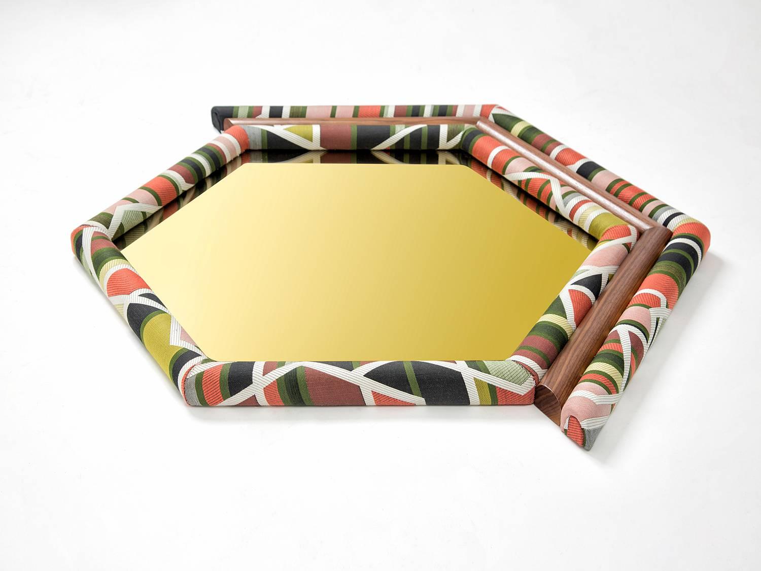 La nouvelle édition de Pontiac Hexagon est encadrée d'un tissu maharam à motifs géométriques, combiné à du noyer américain et à un miroir teinté d'or. La tapisserie a été coupée symétriquement et fabriquée à la main sur du bois et de la mousse.