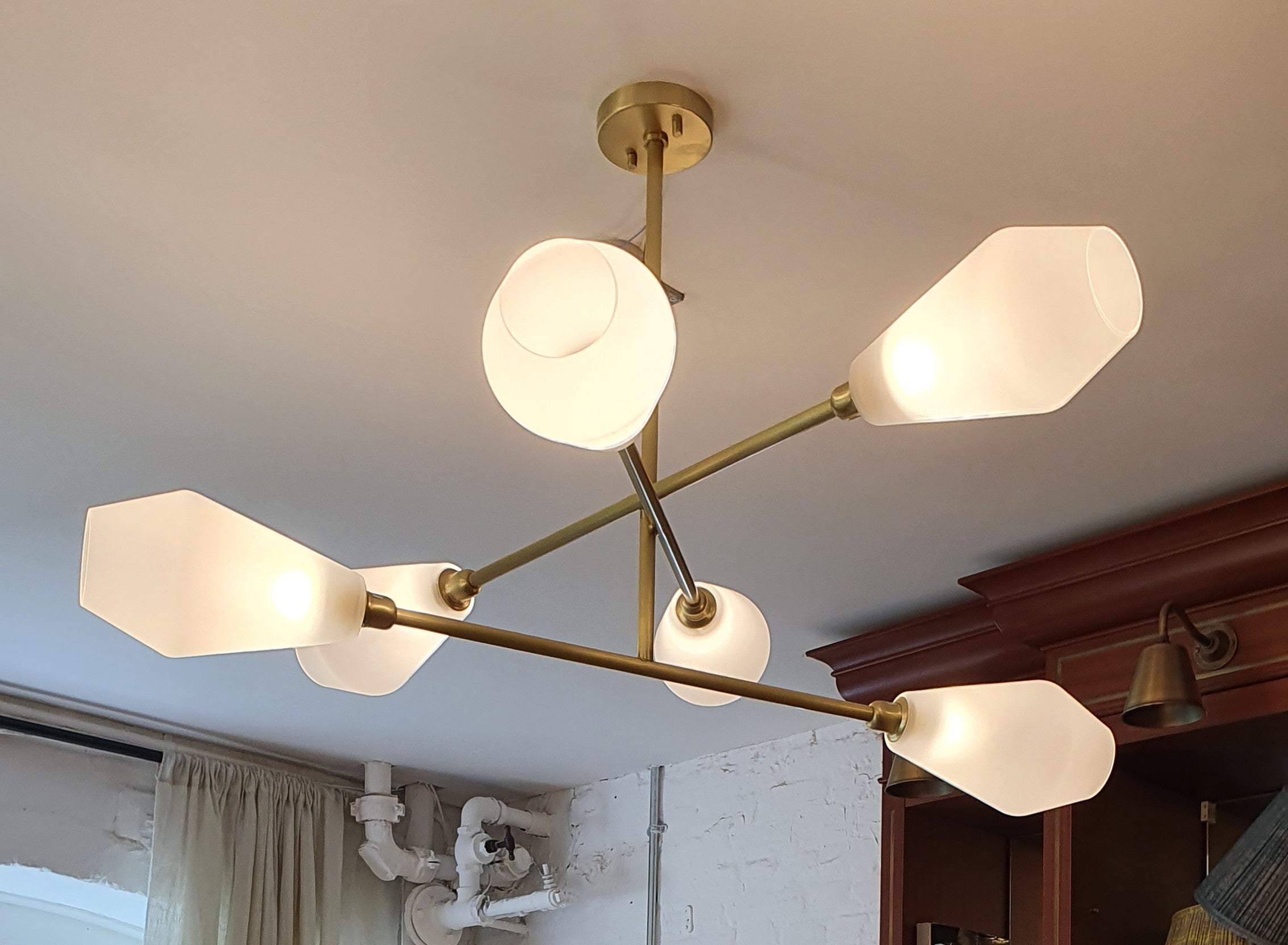 Designed and manufactured by Andrew Kornat Designs this elegant simple minimalist chandelier has been be engineered such that the arms look randomly placed and crossing at different angles, but with total precision in plan

Made from thick grade