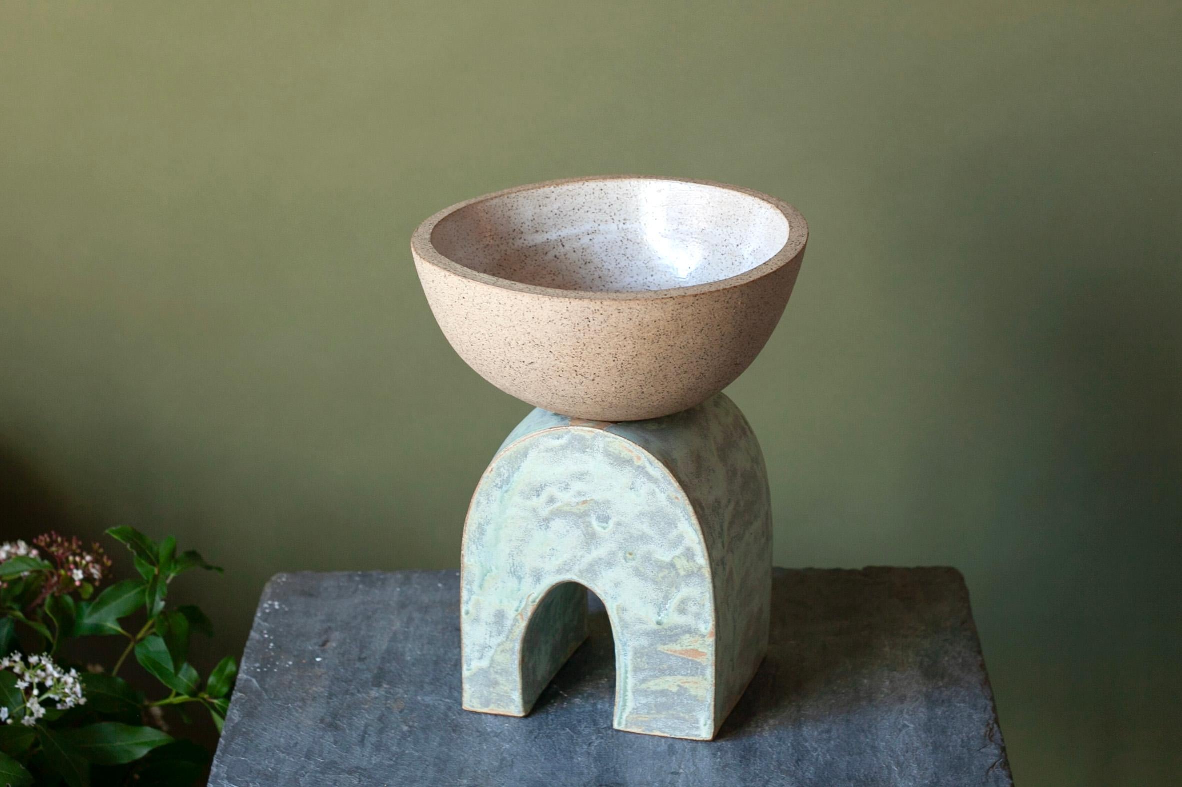 Bol en grès céramique unique, fabriqué à la main.

 La pièce est composée de deux masses d'argile différentes et présente une glaçure artisanale vert cuivré contrastant avec un bol moucheté. Cette pièce a été inspirée par des coquillages et des