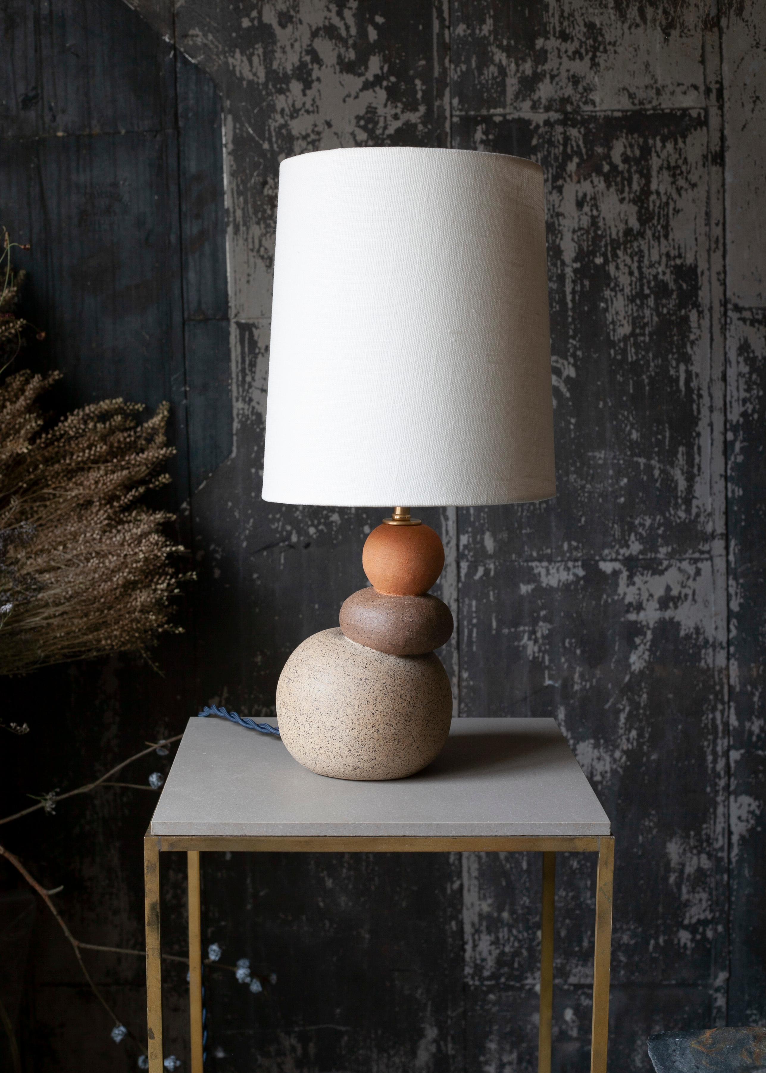 One of a kind ceramic lamp, thrown on the potters wheel and assembled by hand. The lamp base is comprised of three different clay bodies that celebrates the natural texture of unglazed ceramic. This piece was inspired by seashells and smooth stones