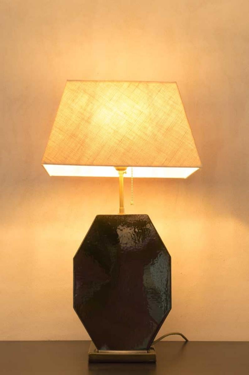 Cette lampe à poser est réalisée en céramique, par un spécialiste de la poterie traditionnelle, avec un extérieur vitrifié pour une plus grande projection de la lumière. L'abat-jour et l'ampoule ne sont pas inclus, mais nous pouvons les vendre