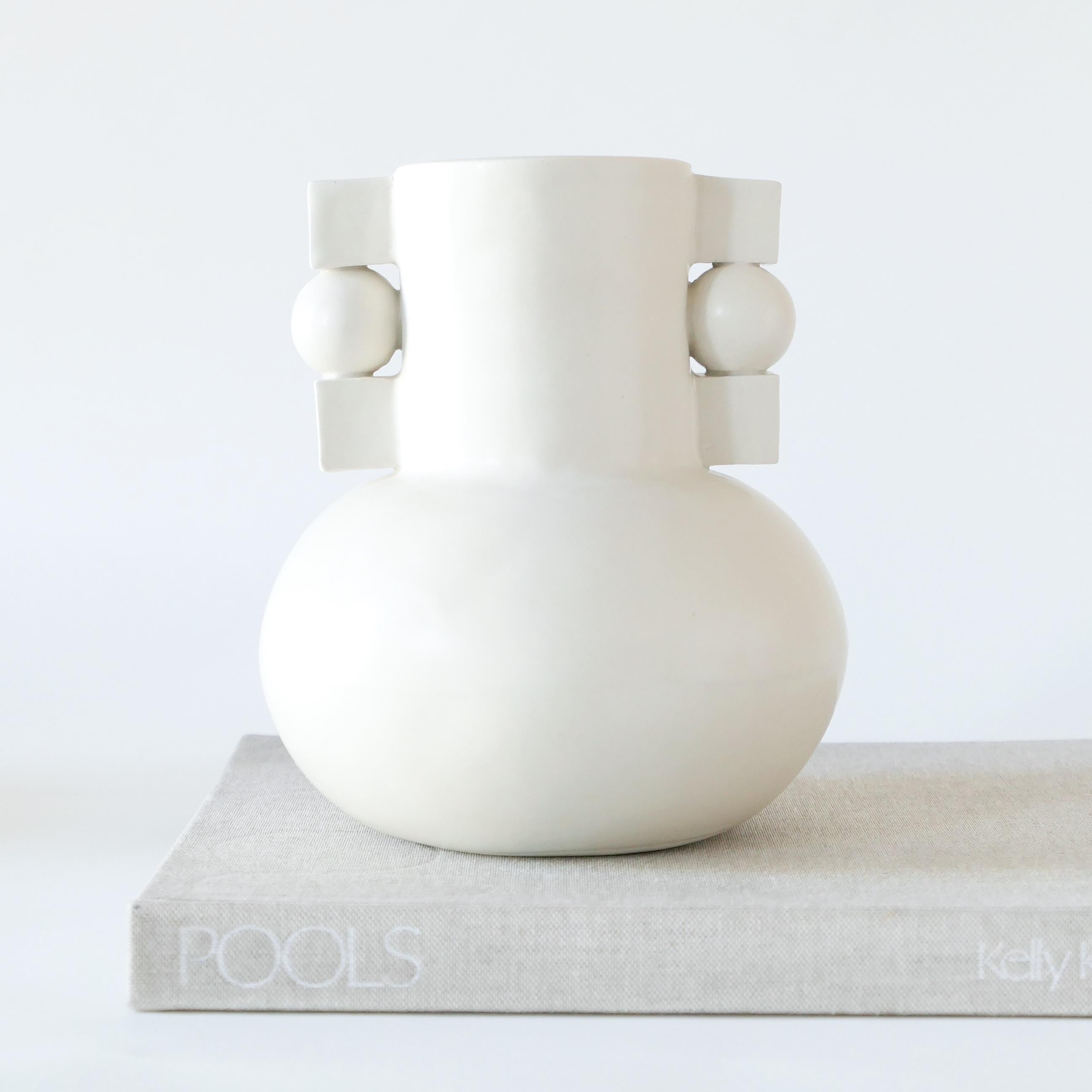 White Bauhaus-inspired stoneware vase, finished with a soft, clear glaze. 

Karina Vieira is a Brooklyn-based ceramicist focusing on handbuilt vessels. 

Her work references various styles, touching on the pre-Hispanic, the Bauhaus and Art Deco,