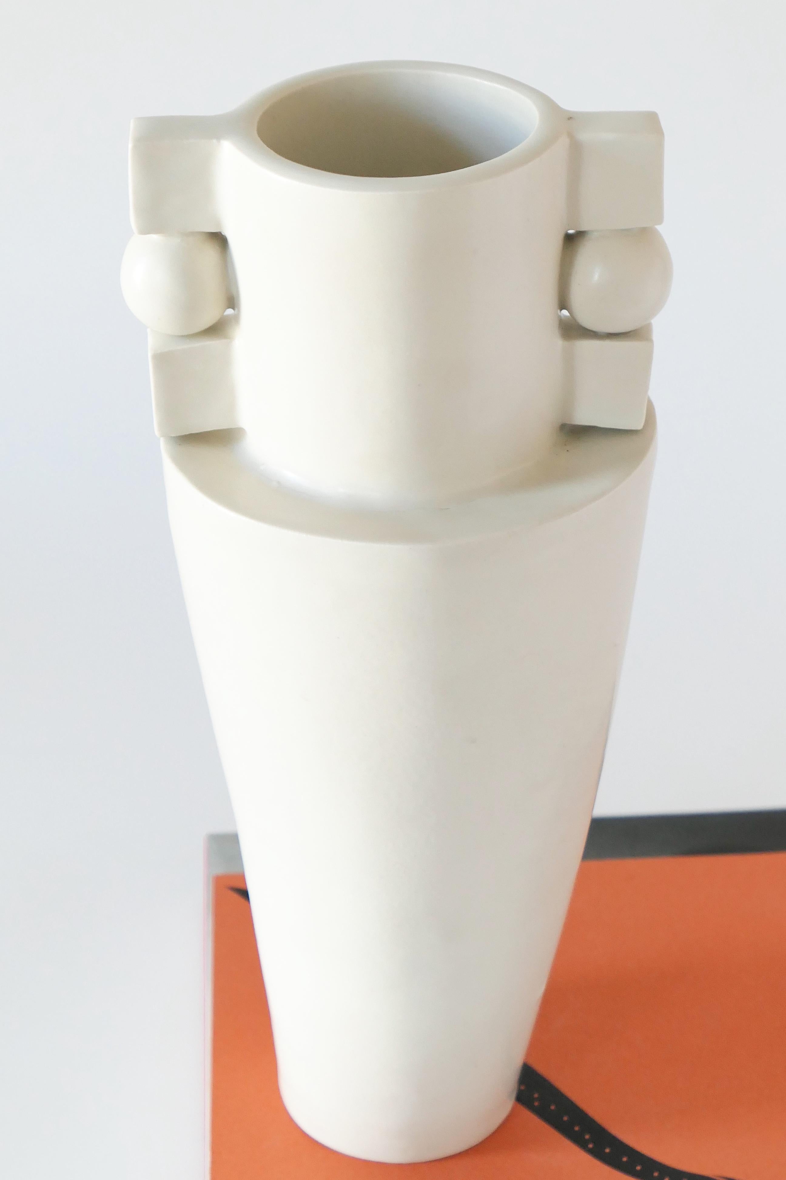 Tall off-white Bauhaus-inspired stoneware vase, finished with a soft, matte white glaze. 

Every piece is made individually and celebrates the slight imperfections intrinsic to handmade. Please note that variations may occur, as well as marks of