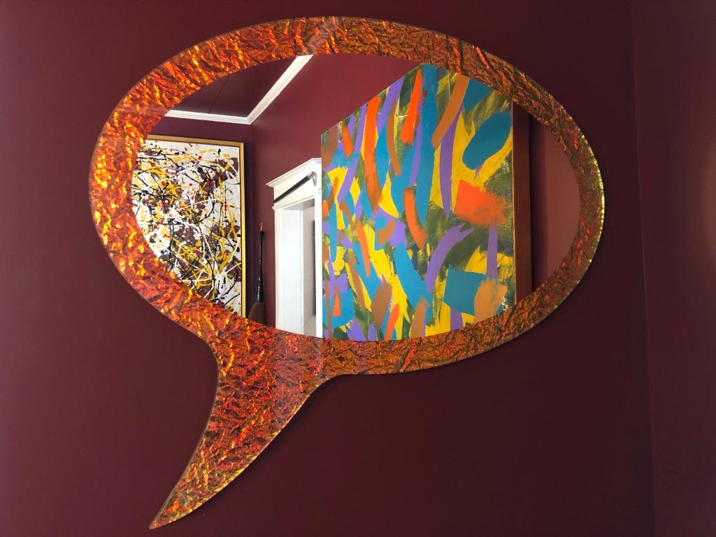 The crazy mirror is cut in the shape of a speech bubble which is familiar to anyone who has ever read comic books or animated novels. The mirror's special effect comes from a dichroic film that gives off a 3D colour-changing look. Crazy glass is