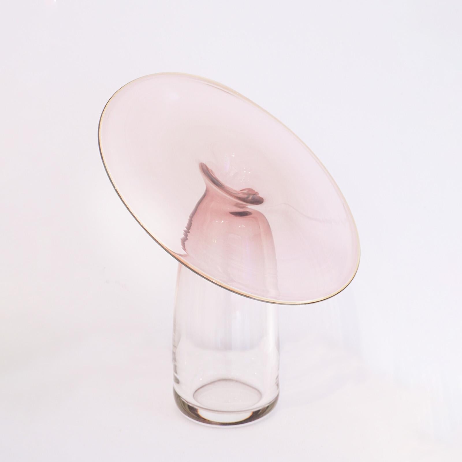“Auris” is a trilogy of blown glass vases, each piece is inspired by the concept of listening, featuring shapes that open like parabolas, designed to receive and amplify sound. The glass, shaped through centrifugal force, creates large, delicate