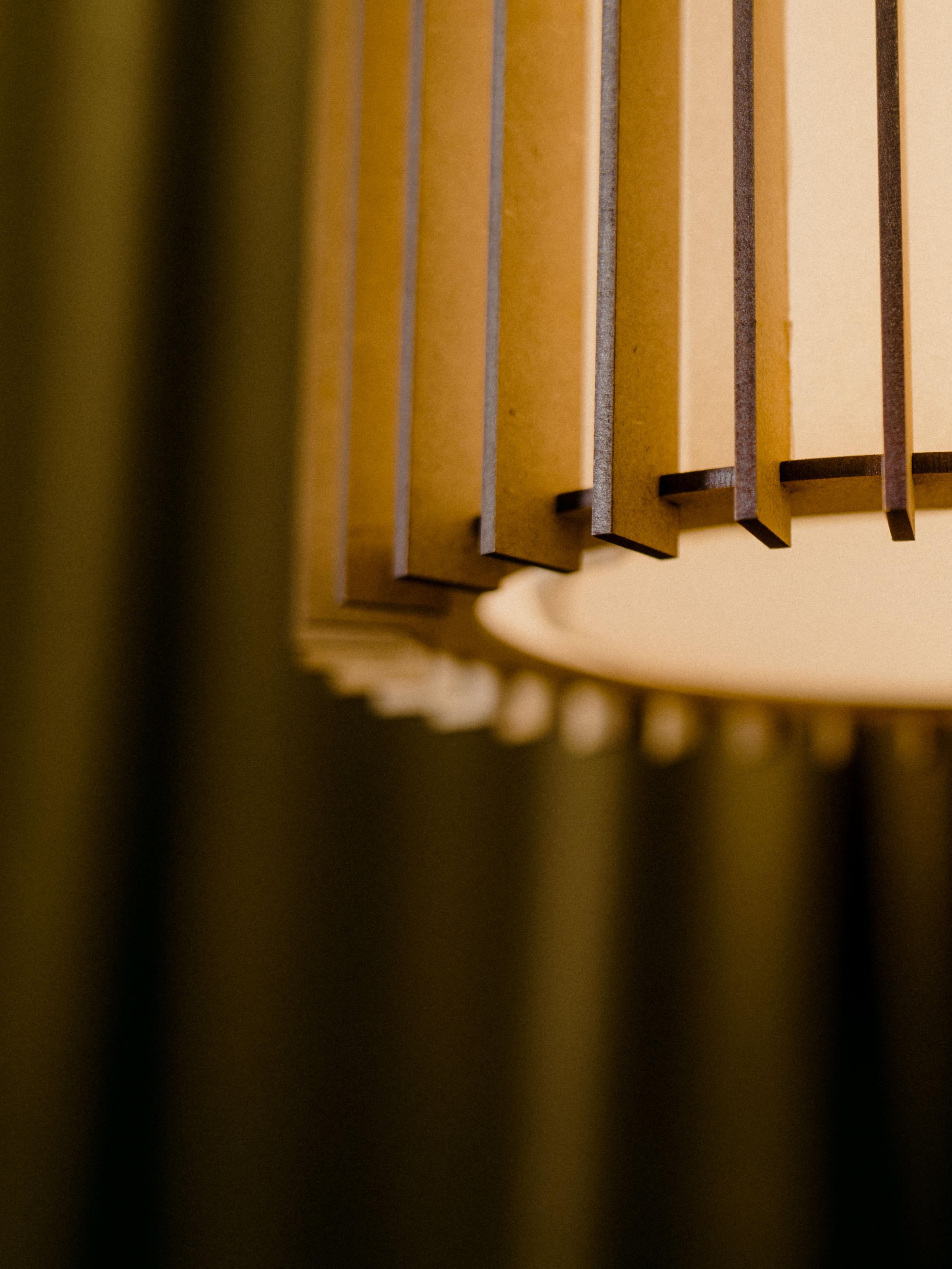 Suau lamps are designed and manufactured by Mediterranean Objects in Barcelona, Spain. 

They have an external screen made of MDF wooden slats, laser cut and assembled one by one, in such a way that they create two different visual textures, one