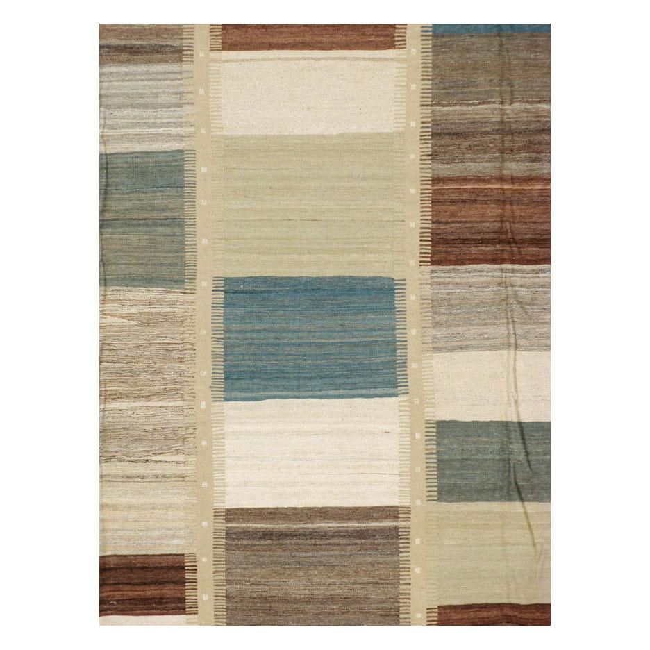 A modern Persian flat-weave Kilim rug handmade during the 21st century. Several rectangles with various tonal colors ranging from light denim blue and grey, ivory, brown, and light pistachio green make up the 5 columns of this pileless room size