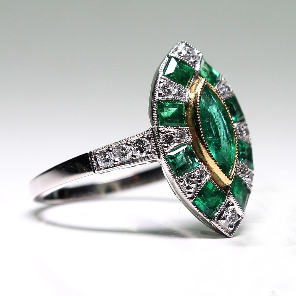 Composition: Platinum

Stones:
•	1 natural Colombian marquise cut emerald that weighs 0.60ctw.
•	8 natural calibrated cut emeralds that weigh 0.80ctw.
•	14 Full cut diamonds of H-VS2 quality that weigh 0.30ctw. 

Ring face:  18mm by 12mm 
Rise above