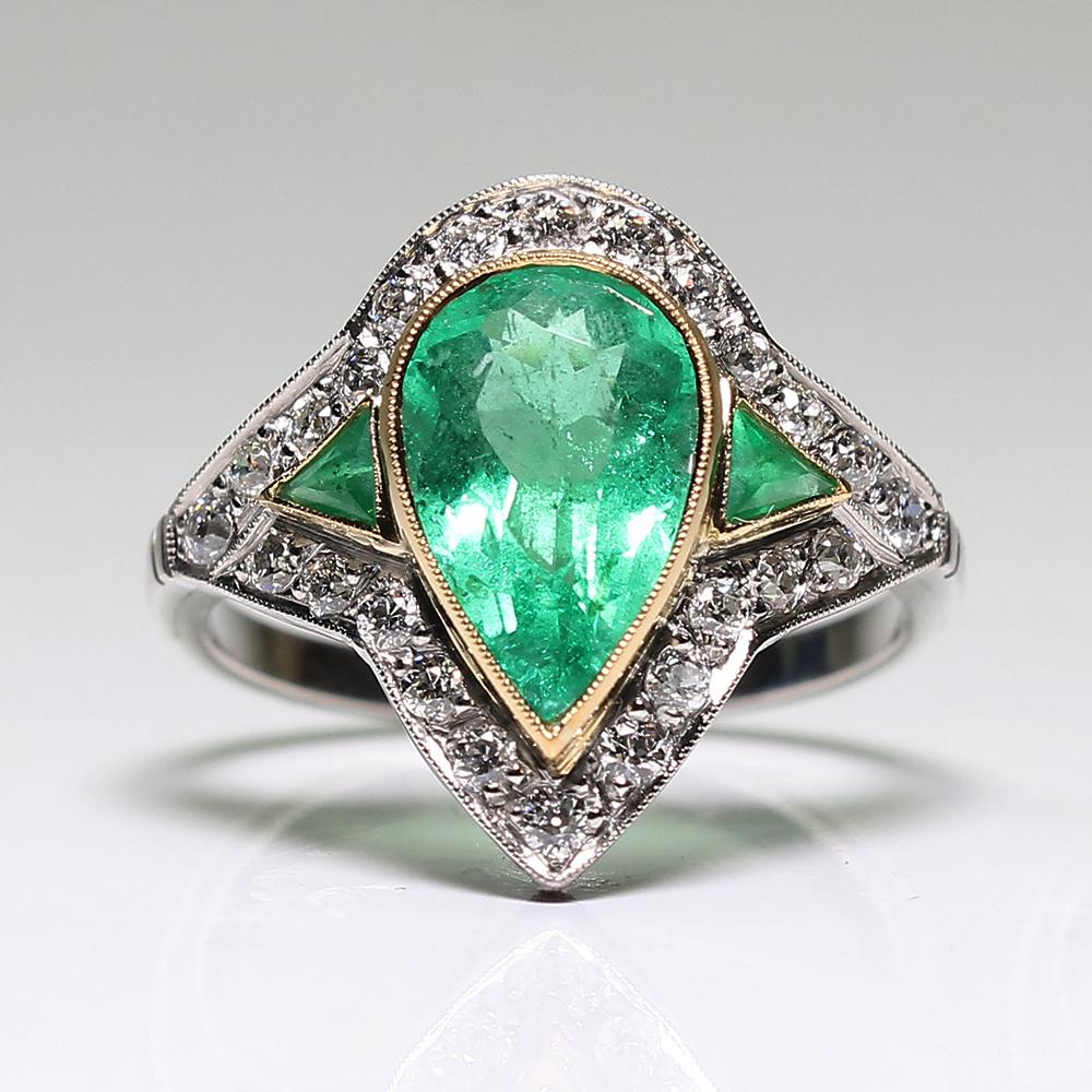 Period: Art Deco (1920-1935)
Composition: Platinum
Stones:
•	1 natural pear cut emerald that weighs 1.56ctw. 
•	2 natural calibrated French cut emeralds that weigh 0.30ctw.
•	24 Old mine cut diamonds of H-VS2 quality that weigh 0.50ctw.
Ring size: 6