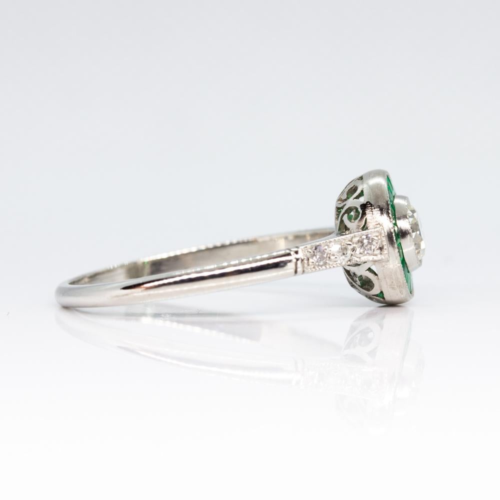 Composition: Platinum
Stones:
• 1 Old mine cut diamond I-VS2 0.30ctw
• 16 natural emeralds 0.50ctw
• 6 old mine cut diamonds I-VS2 0.06ctw
Ring size: 7 
Ring face:  8mm
Rise above finger: 5mm.¬
Total weight:  2.9grams – 1.9dwt 
Appraisal available