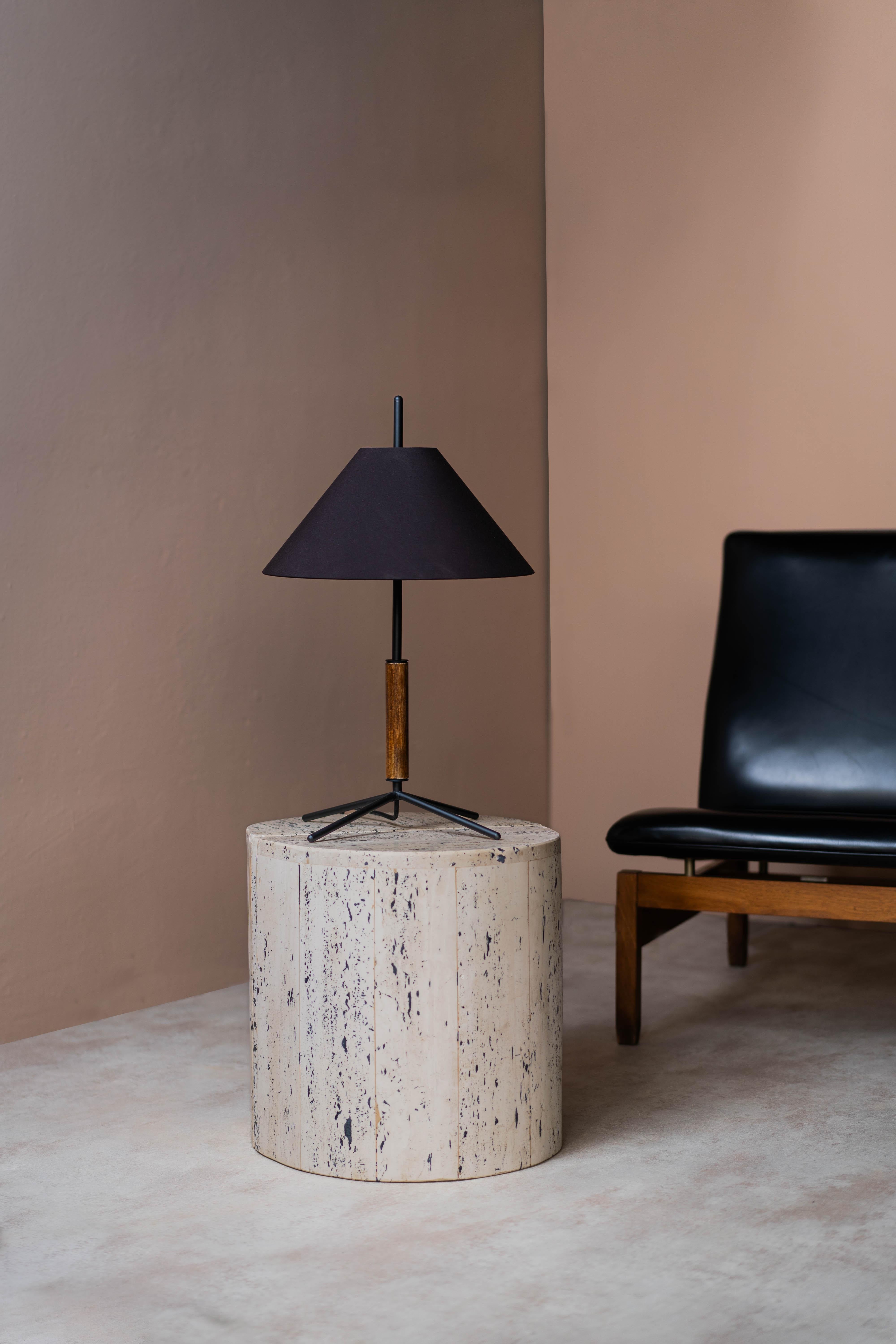 The VOL table lamp has a simple combination of lines and volumes, which create a geometric sculptural form, while being optimal in its shape for lighting spaces. 
It has a conical shade, a structure that combines metal with natural wood, and a