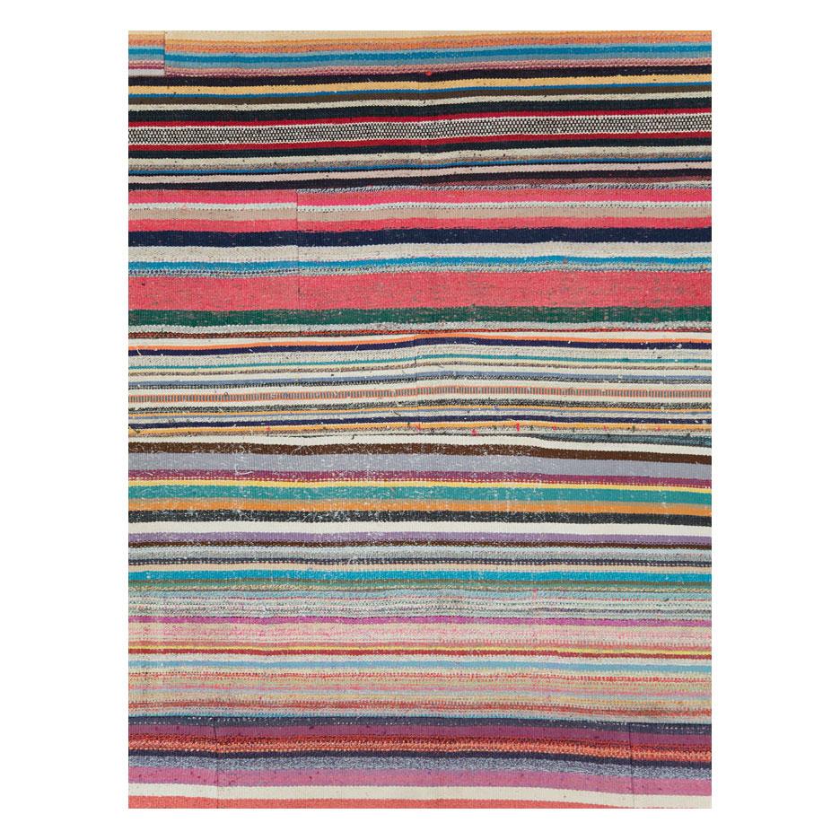 Ein moderner türkischer flachgewebter Kilim-Teppich mit buntem, horizontal gestreiftem Muster, der im 21. Jahrhundert handgefertigt wurde. Mit seinen leuchtenden und skurrilen Farben ist er ein Blickfang.

Maße: 11' 0