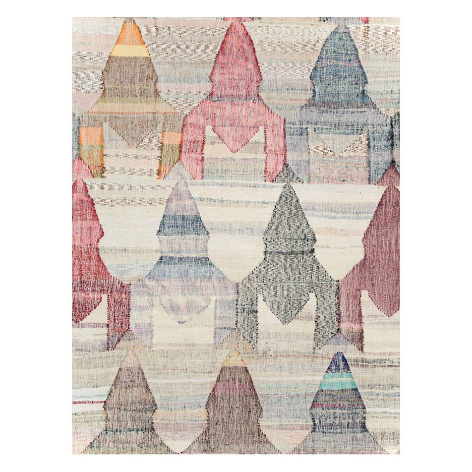 Moderna alfombra Kilim turca de tejido plano y gran tamaño, hecha a mano en el siglo XXI, con un colorido motivo geométrico a gran escala que recuerda a las carpas de un circo, sobre un fondo blanco-beige.

Medidas: 13' 4