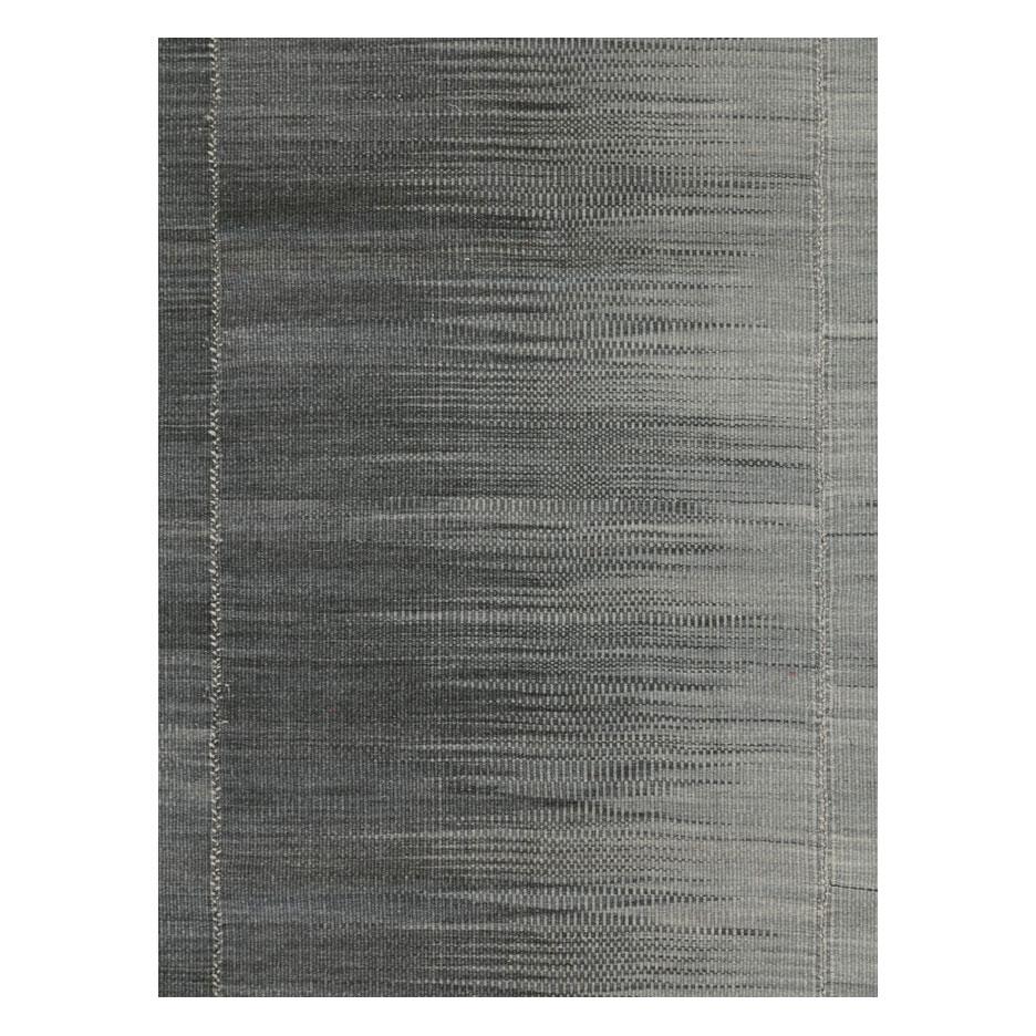 A modern Turkish flat-weave Kilim accent rug handmade during the 21st century with a contemporary design in black, charcoal, and grey.

Measures: 7' 0