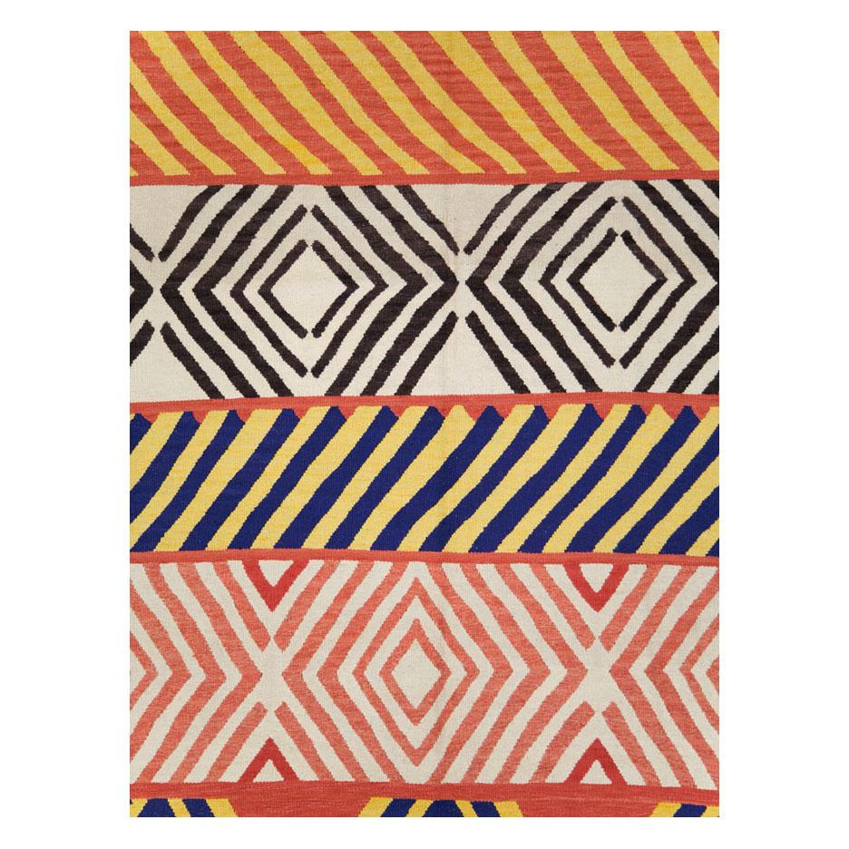 Ein moderner türkischer Flachgewebe-Kilim-Teppich für große Räume, handgefertigt im 21. Jahrhundert mit einigen Stammesmusterelementen in geometrischer Form.

Maße: 10' 3