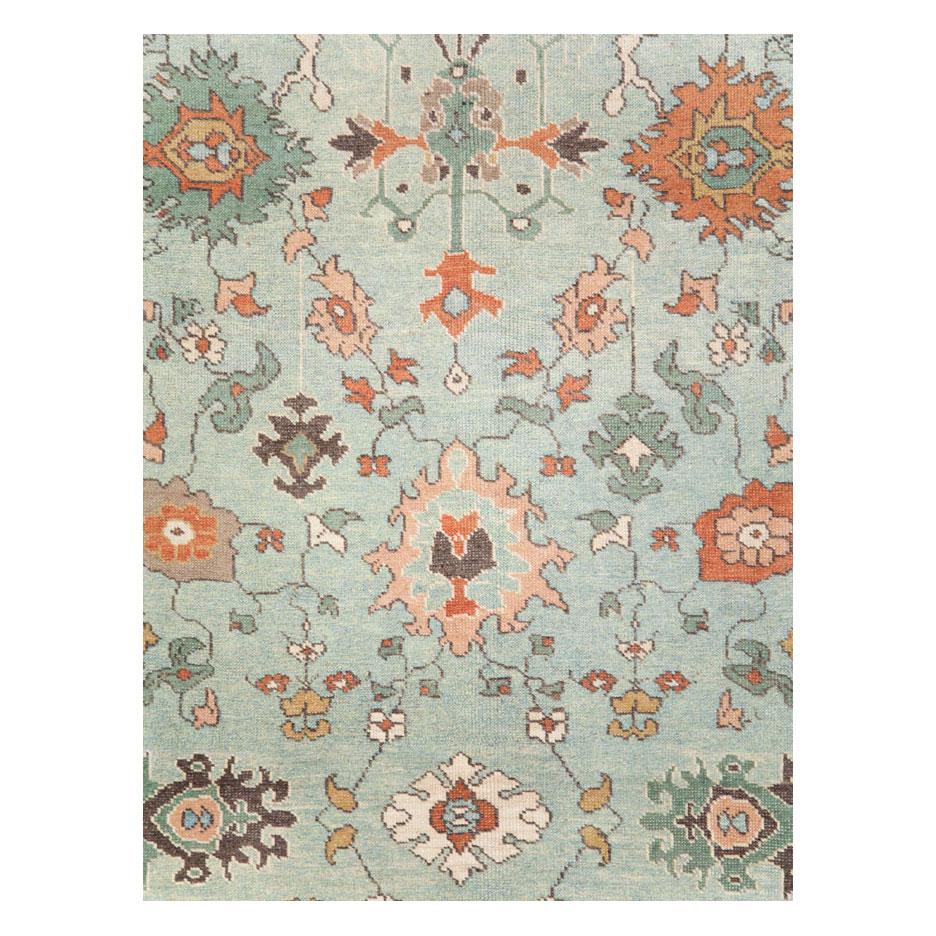 Un tapis d'accent moderne de style turc Oushak fait à la main au cours du 21e siècle avec un champ bleu marine et une bordure ivoire, et quelques palmettes en orange brûlé.

Mesures : 7' 2