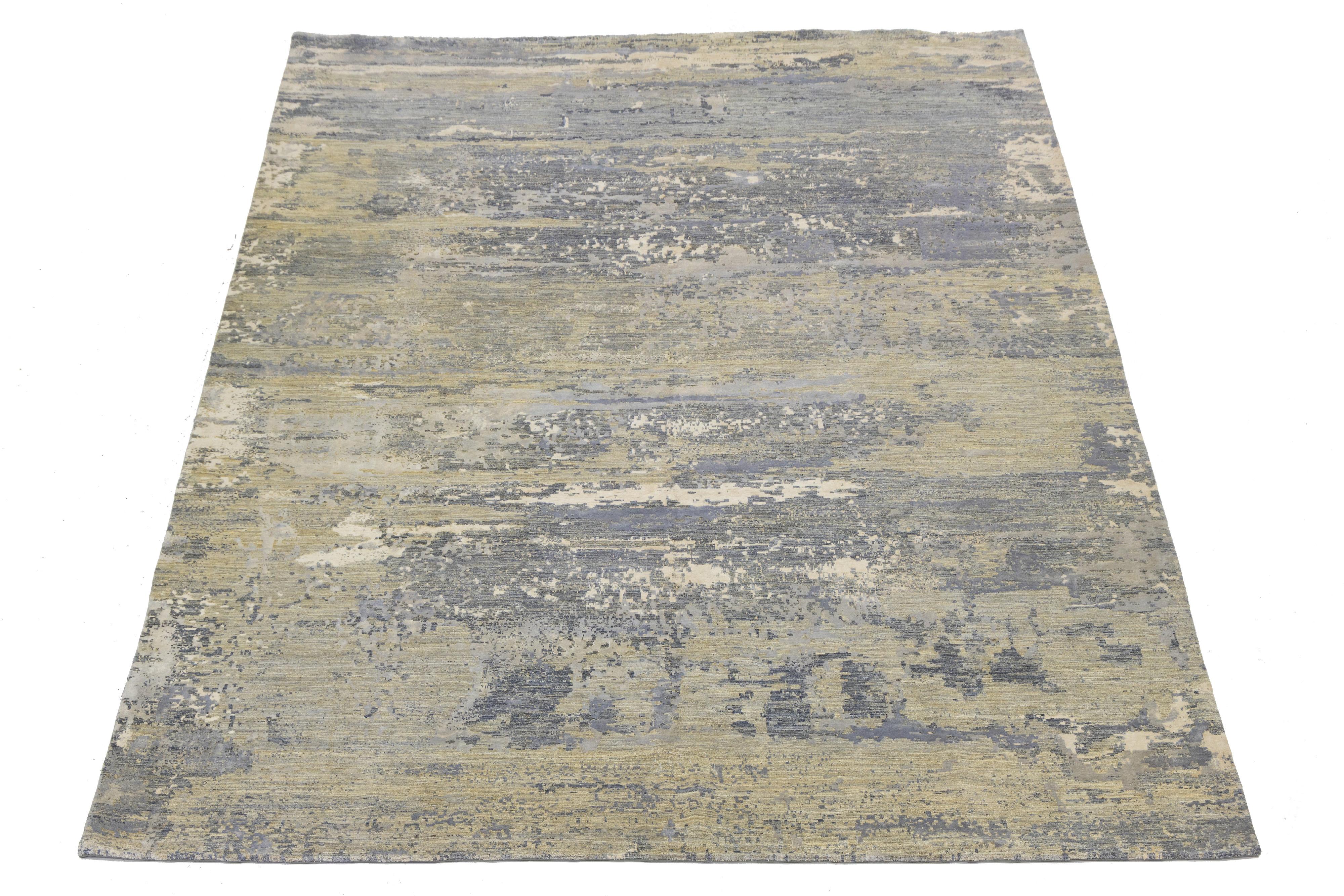 This contemporary hand-knotted rug features a stunning design with a vibrant color scheme. Made from high-quality wool or silk, it has a gray and beige background that beautifully showcases the intricate pattern, adding artistic flair and