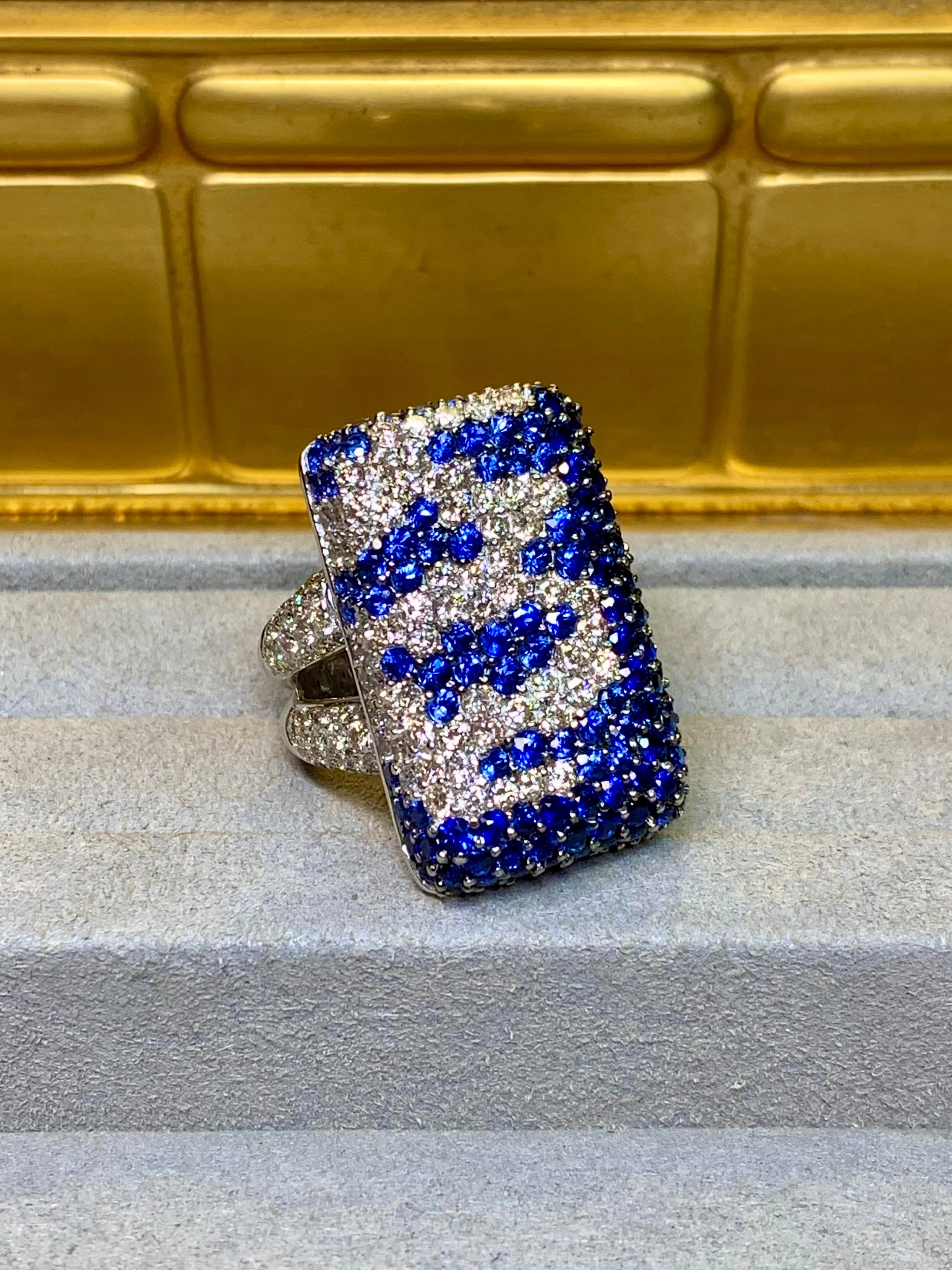 An exceptionally well made and substantial cocktail ring crafted in heavy 18K white gold and expertly pavé set with approximately 7.15ctw in vibrant blue round cut sapphires as well as 4.45ctw in G-H color Vs1-2 clarity well matched round diamonds.