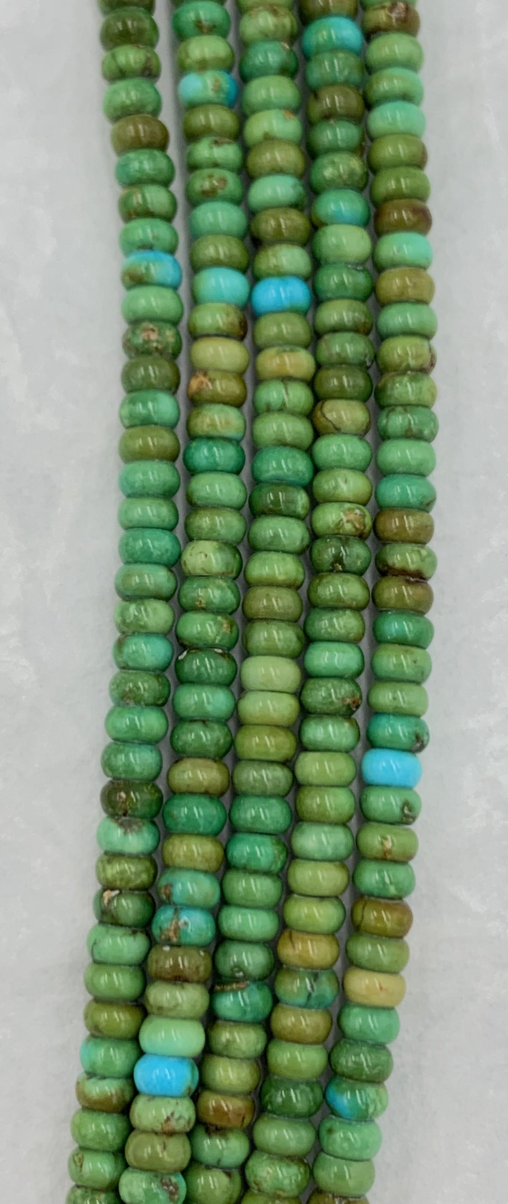 Contemporary Heishi style Sonoran Gold turquoise beads necklace with five strands. The necklace has silver cones at both ends. 

Sonoran Gold Turquoise is mined in Sonora, Mexico near the city of Cananea. The mine is located at the Campitos Mountain
