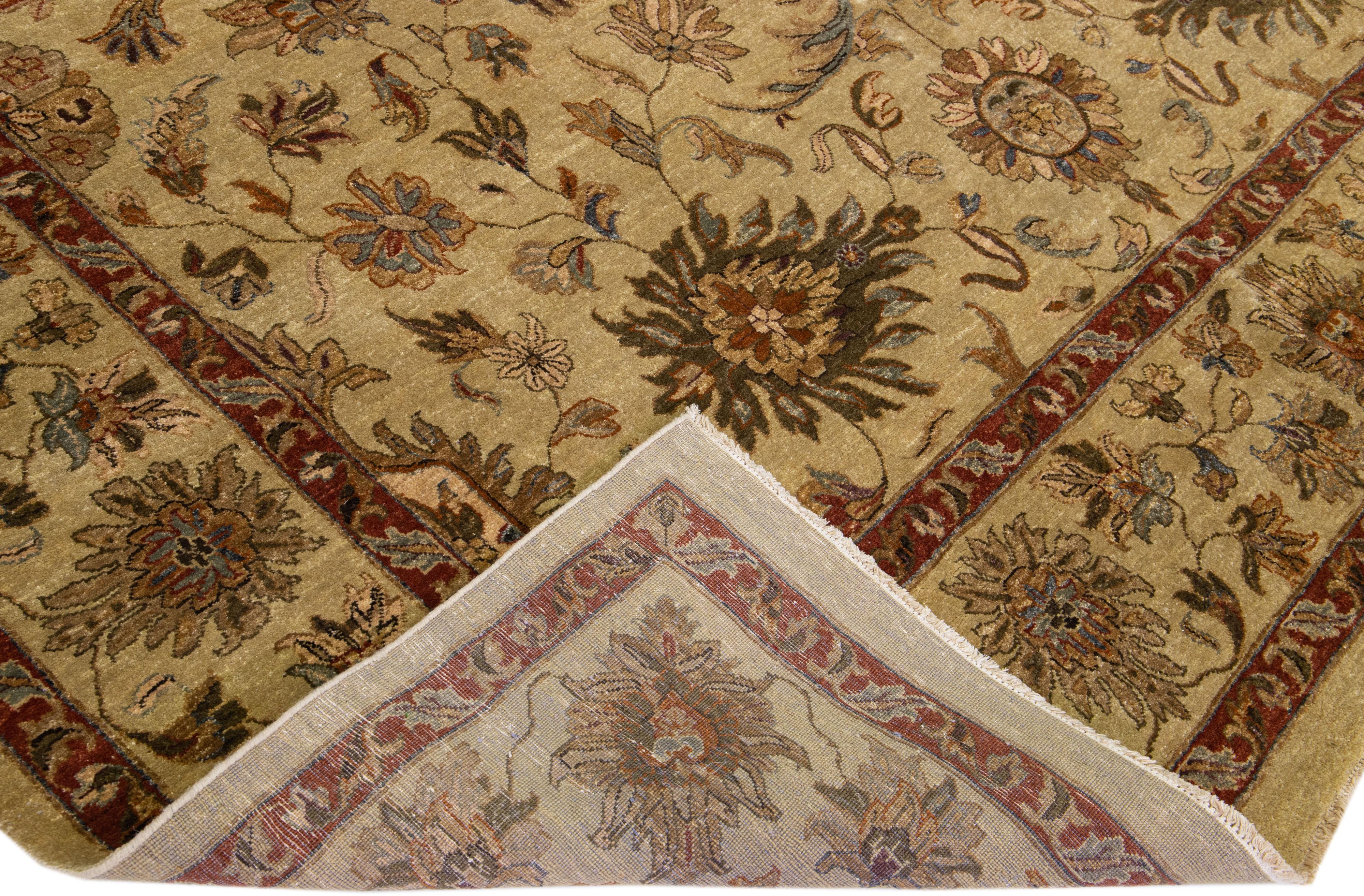 Beautiful antique Indian hand-knotted wool rug with a tan color field. This piece has a gorgeous floral design and a red, brown, and green accent.

This rug measures 10' x 14'.

Our rugs are professional cleaning before shipping.