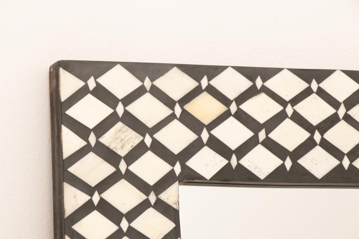 An Indian rectangular mirror in a black resin frame with bone inlay in a diamond pattern.