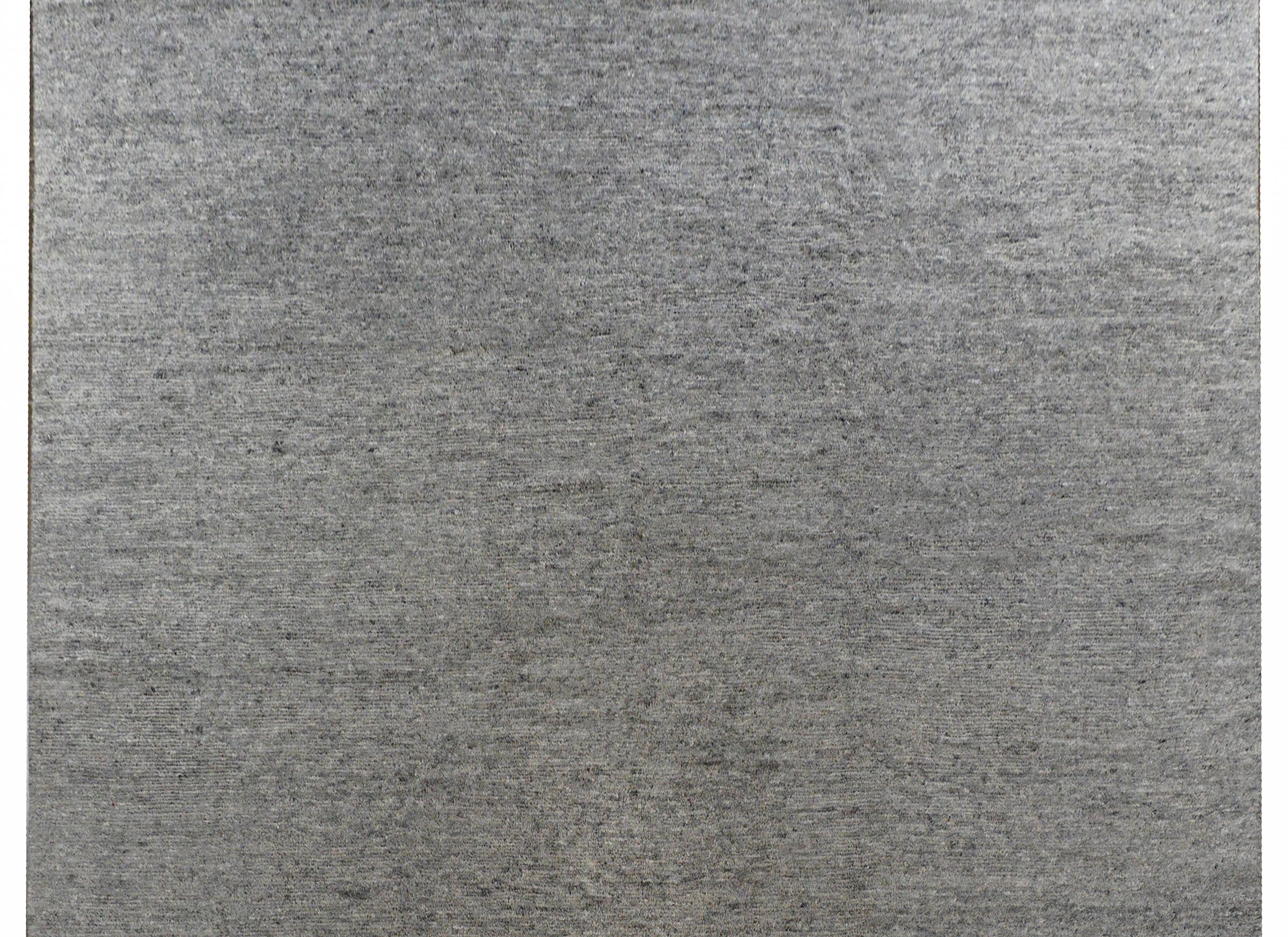 A sophisticated contemporary hand knotted Indian Zephyer rug woven with a rich variegated charcoal wool, with no border.