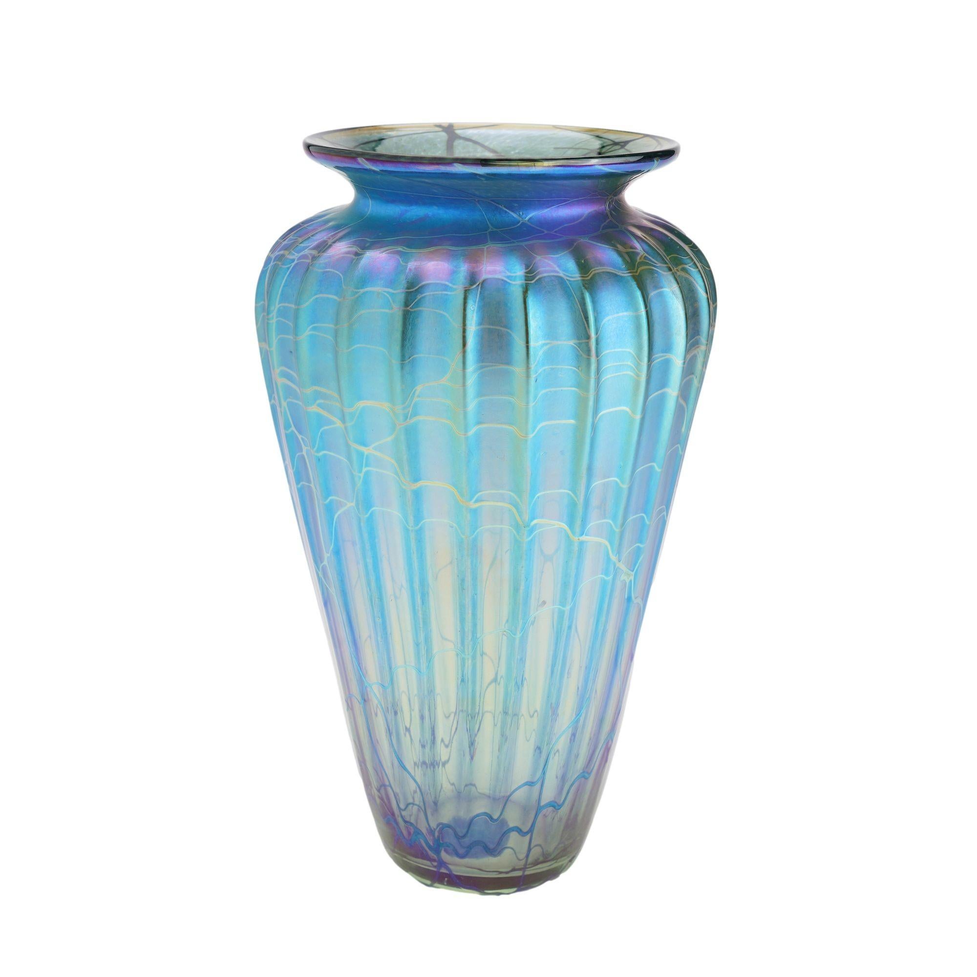 Iridescent blue blown glass vase with a tapered and fluted body, footed vase, and waisted flared rim. The glass has exceptional depth to it and the iridescence is luminous in shades of blue and purple.
Manhattan Beach, California, 2015.