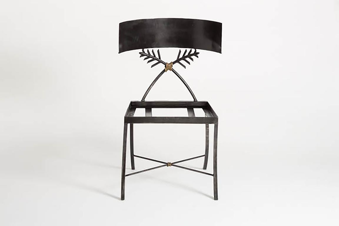 La chaise klismos classique en fer de la collection Maison de Tara Shaw est ornée de motifs de frondes de palmiers et d'un nœud délicat de couleur bronze. Cette chaise s'adapte à tous les styles de décoration. Fabriqué à la main à la