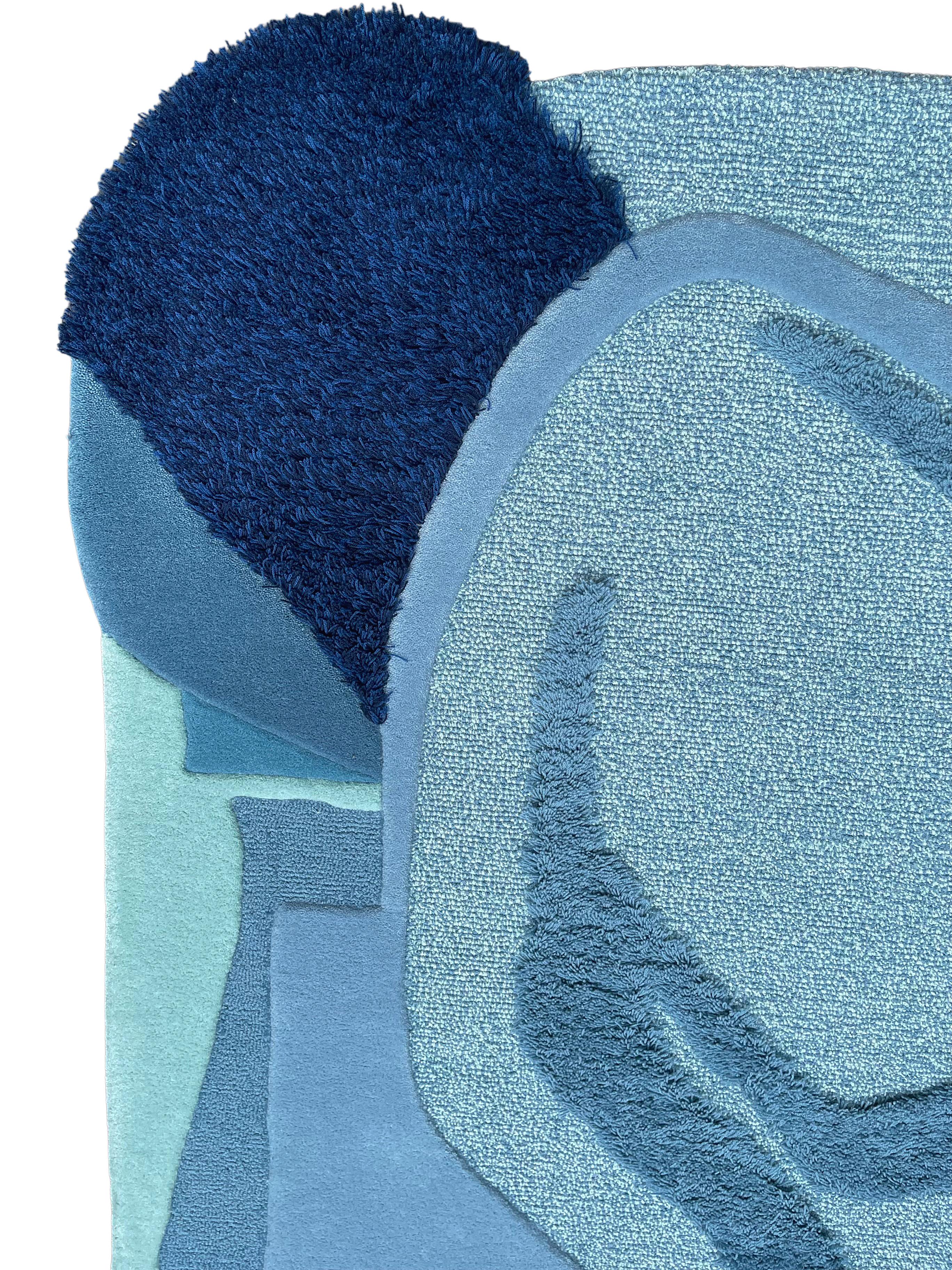 Earth Day Bleu ! est un tapis contemporain en laine touffetée à la main de forme irrégulière avec un mélange de couleurs bleues 

Un tapis inspiré des courants de l'océan et des Cumulonimbus ; sources d'eau - l'essence même de la vie. Reproduisez