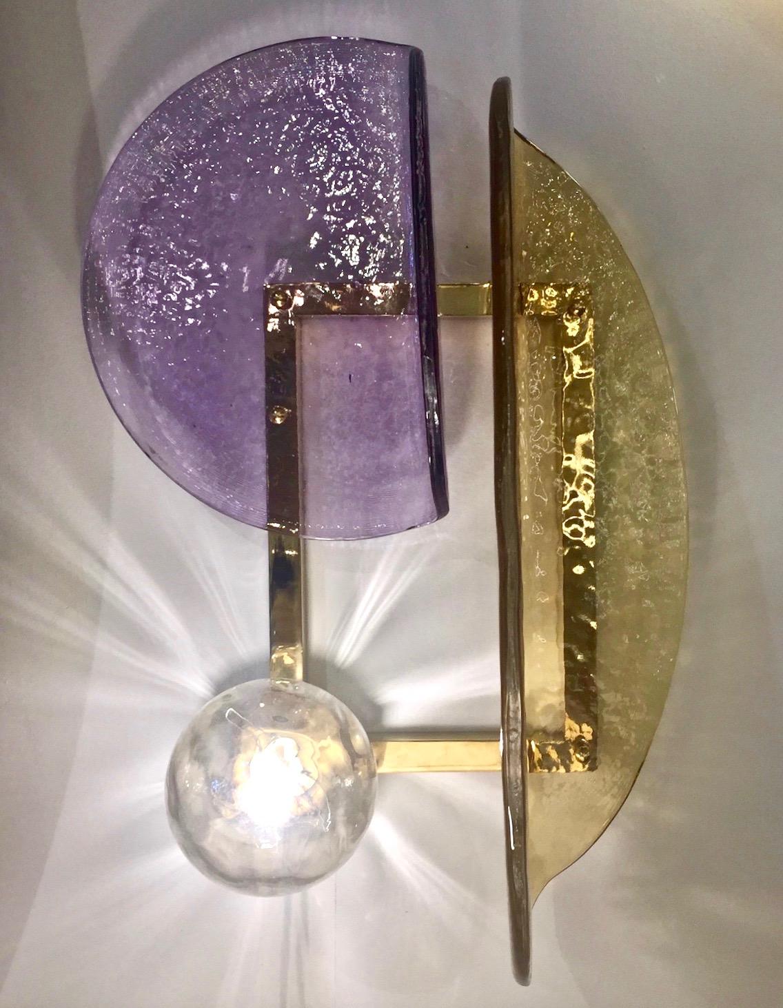 One sconce is available now - A contemporary creation with a unique modern geometric design, this wall light is entirely handcrafted in Italy. The molded textured glass elements of organic rounded shape, in amber gold and purple violet Murano glass,