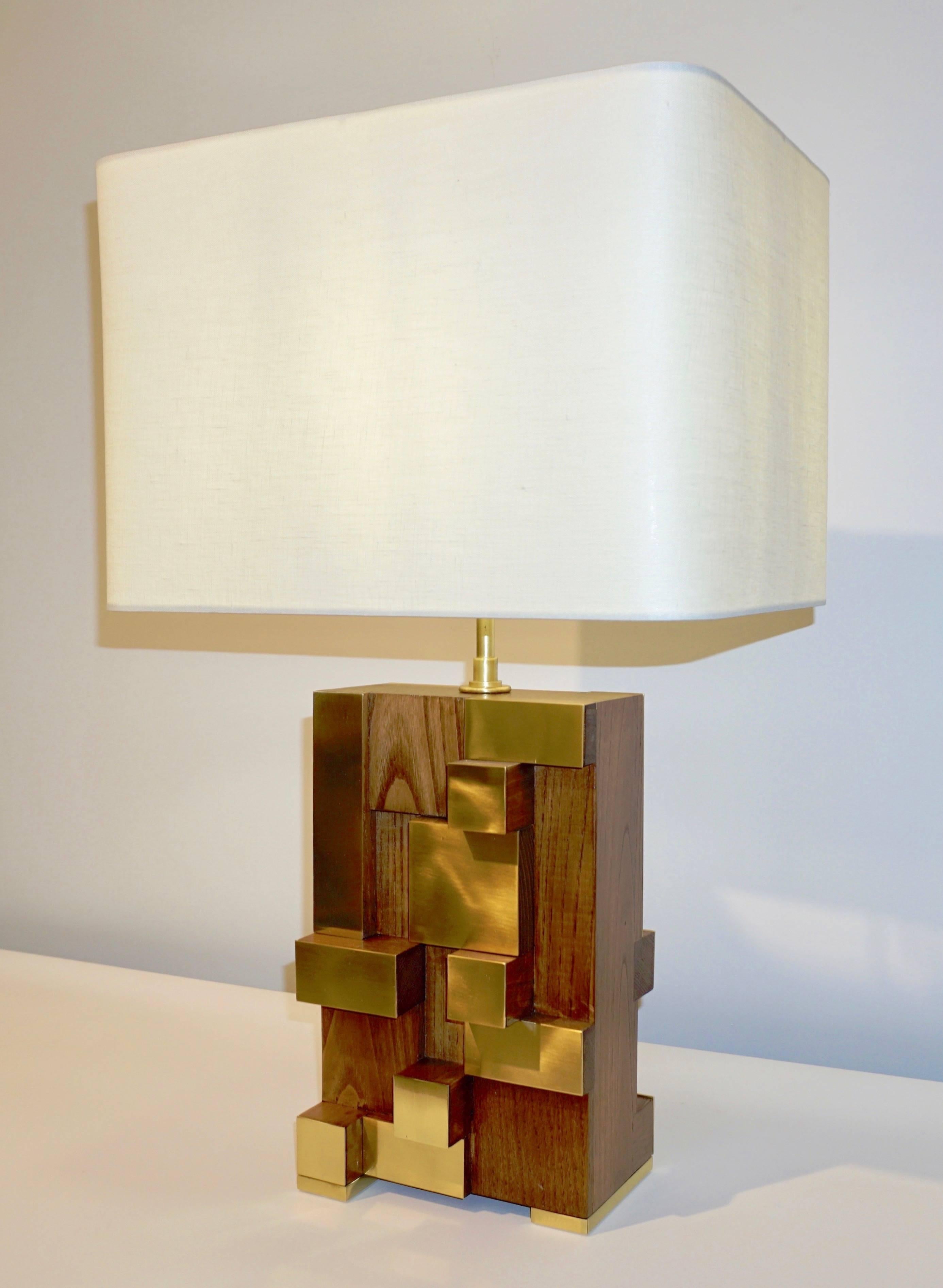 A very interesting Italian Fine Design pair of bespoke Minimalist wood sculpture lamps, entirely handcrafted in walnut and brass, presenting an exclusive modern geometric Design with a very unique Urban inspiration accented by the stepped