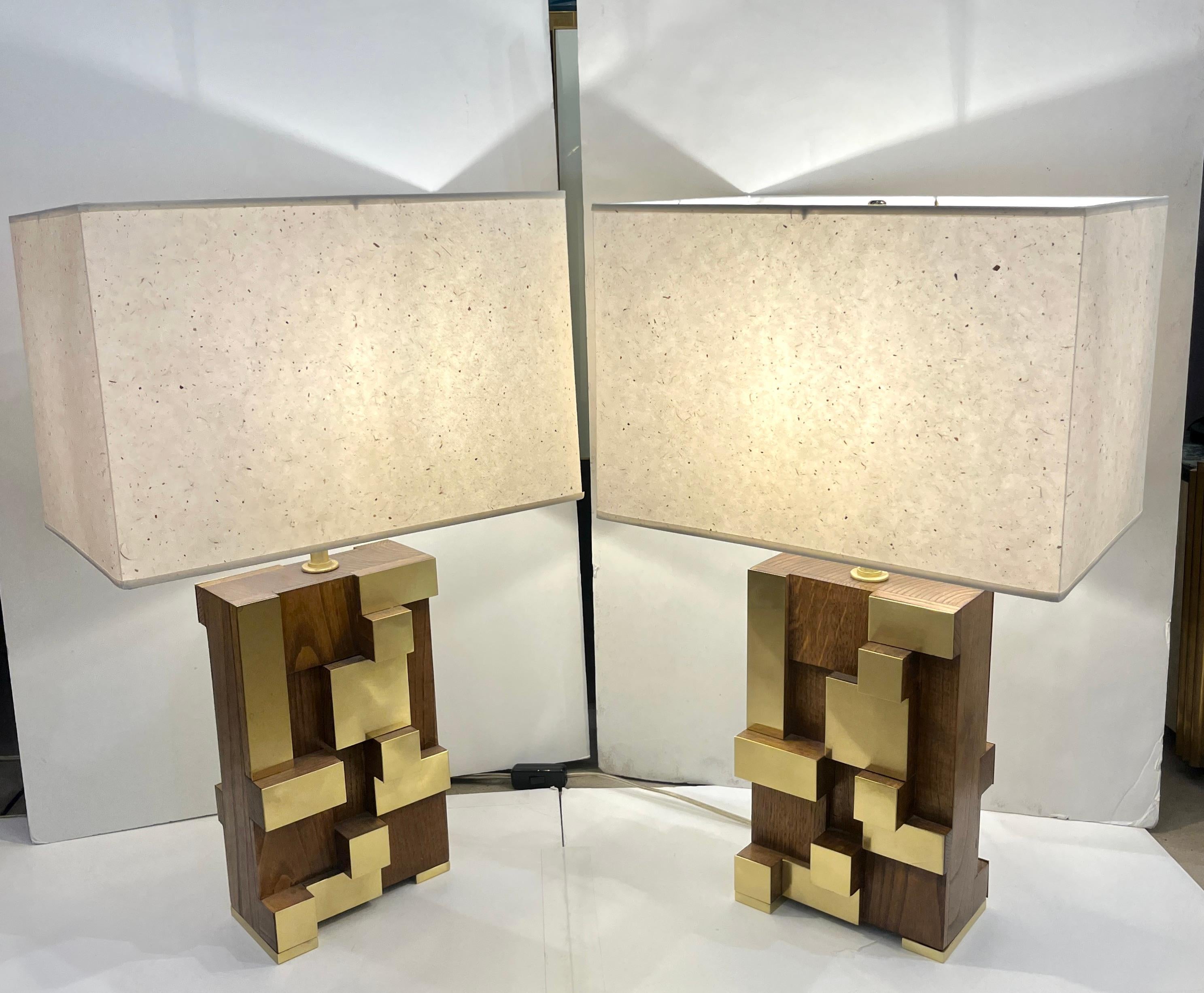 Un par muy interesante de lámparas minimalistas de madera de diseño italiano, hechas a mano en nogal y latón, que presentan un exclusivo diseño geométrico moderno con una inspiración urbana muy singular acentuada por la decoración escalonada,