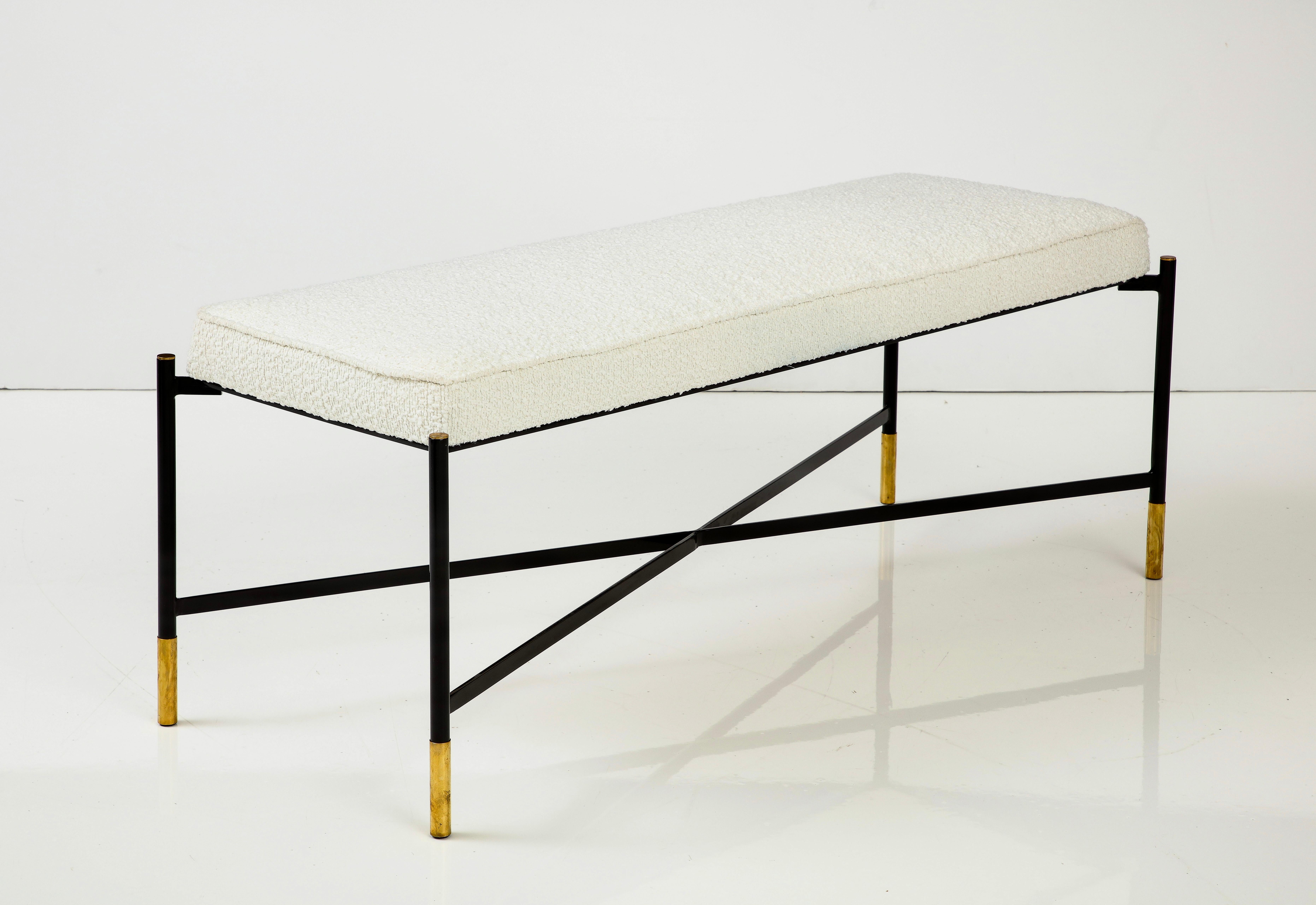 Chic and sleek contemporary Italian bench with black enameled base with cross stretchers accessorized with brass hardware and upholstered with a tight seat in Italian off-white boucle fabric. This stylish and versatile piece is perfect for a hallway