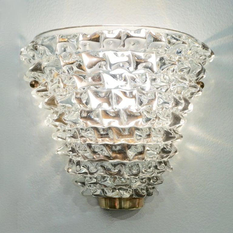 Organic sculpture of crystal clear Murano glass wall light in the style of Barovier Toso, with a cone shape, made using the rostrato technique on a natural brass hand-made and hand-cut plate.
Options for finishes and glass colors.