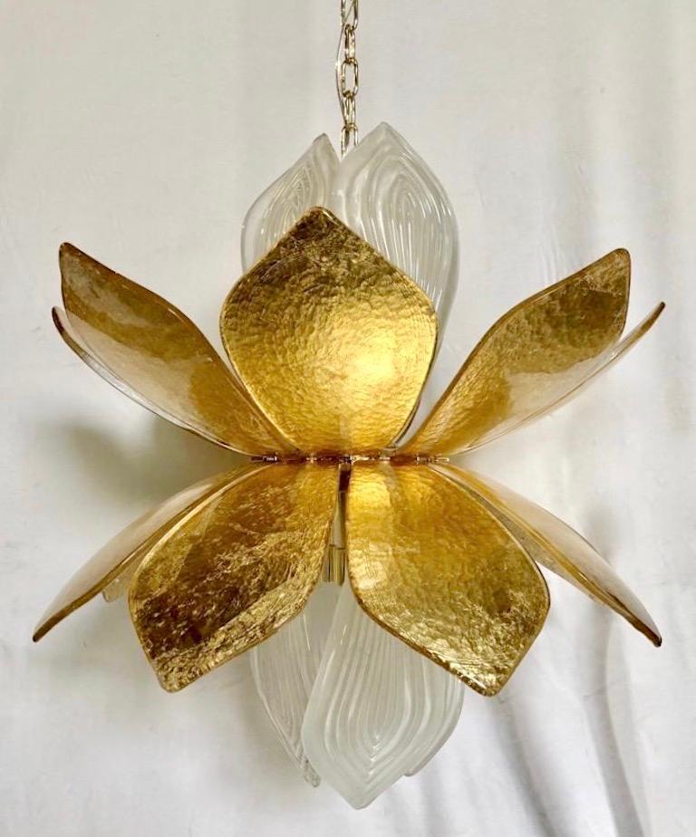 This is an exclusive organic design, entirely handcrafted in Murano - Italy, in the shape of a lotus flower with textured white frosted reeded Murano glass leaves coming out of a corolla of glass leaves hand worked with pure gold. Fitted with 8 G9