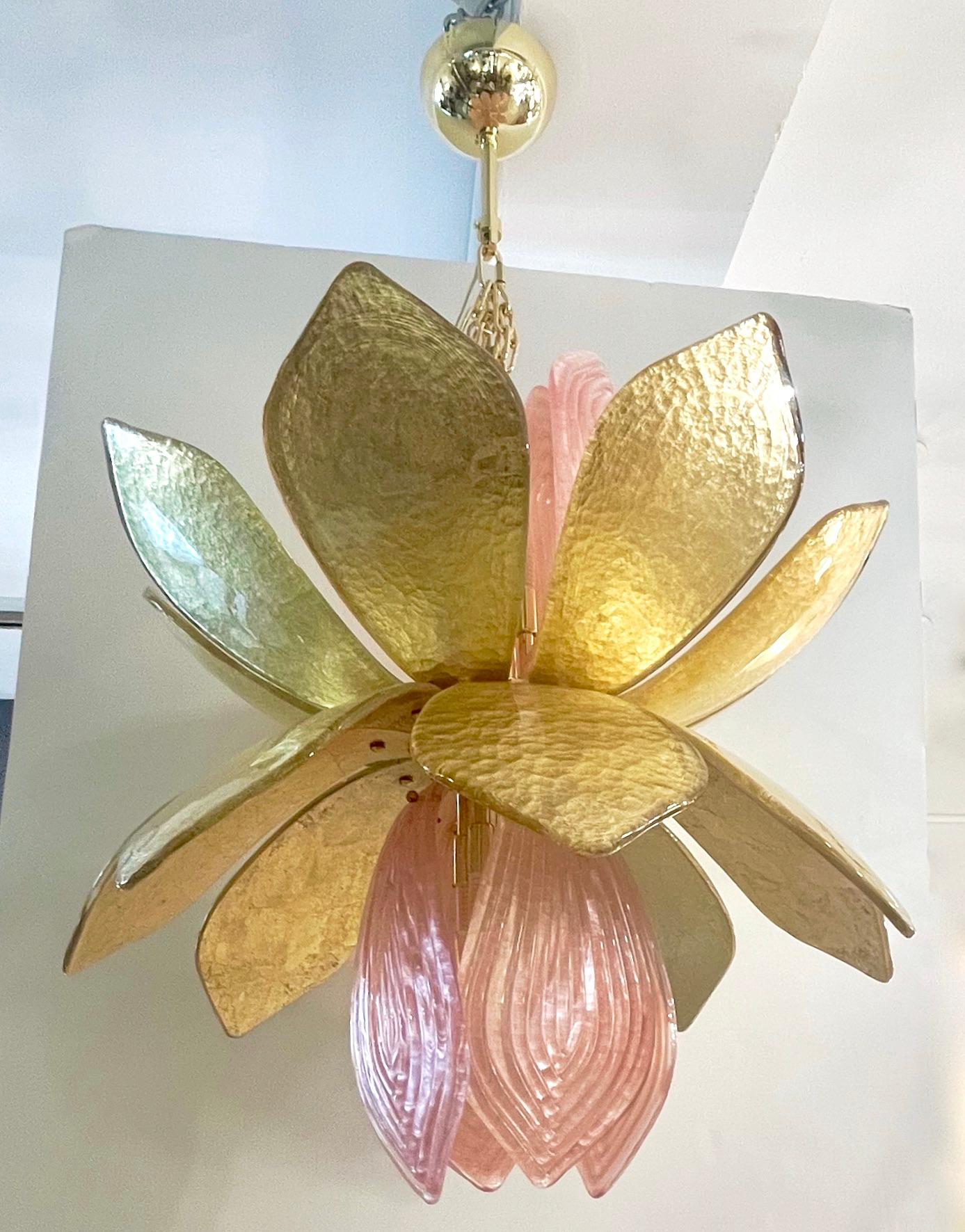 This is an exclusive organic design, entirely handcrafted in Murano - Italy, in the shape of a lotus flower with textured pink frosted reeded Murano glass leaves coming out of a corolla of glass leaves hand worked with pure gold. Fitted with 8 G9