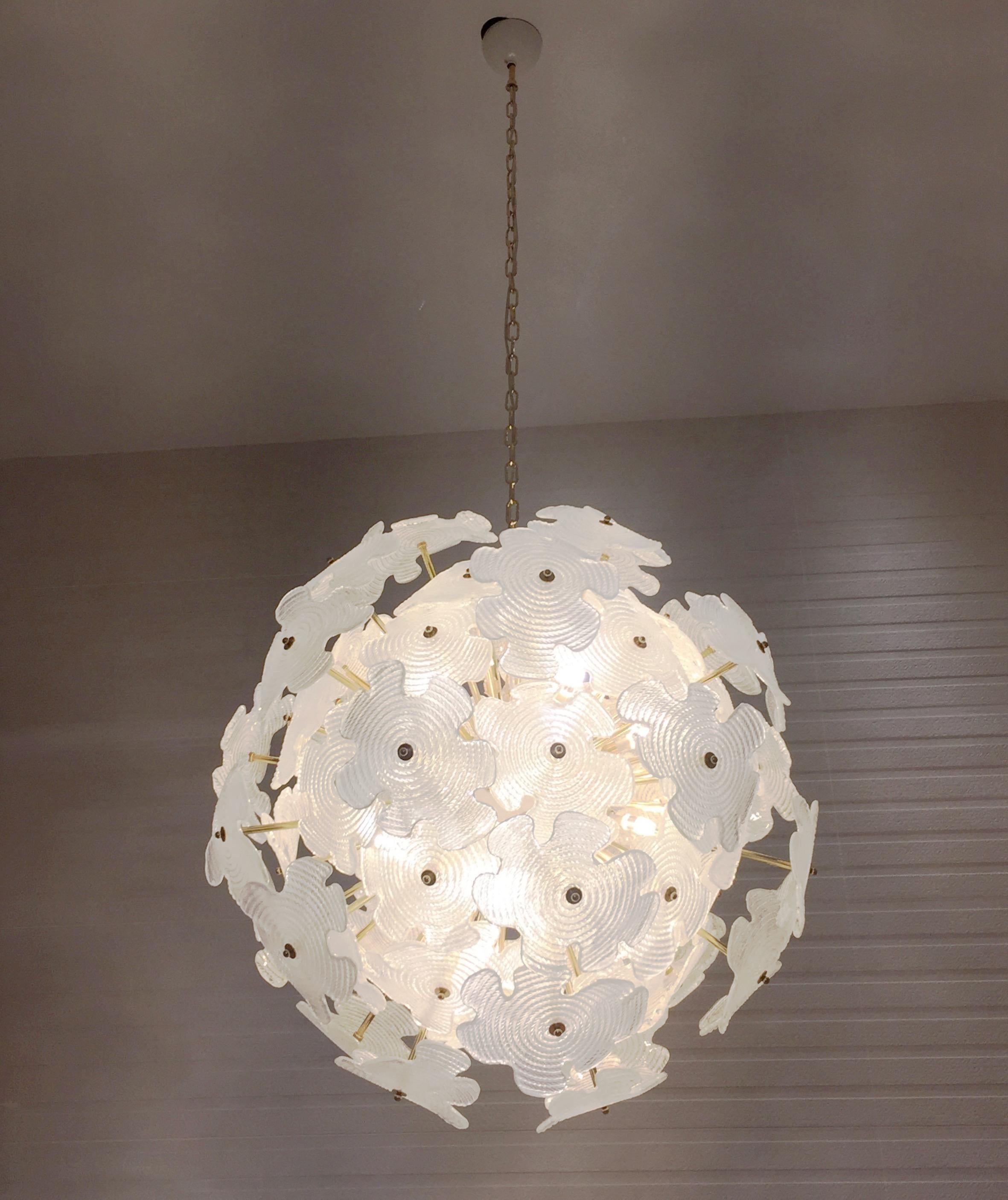 A very elegant sputnik chandelier, entirely hand made in Italy, with a round design showing exquisite details of construction and high quality of craftsmanship. A central sphere, in white cold painted brass, supports a cluster of intertwined