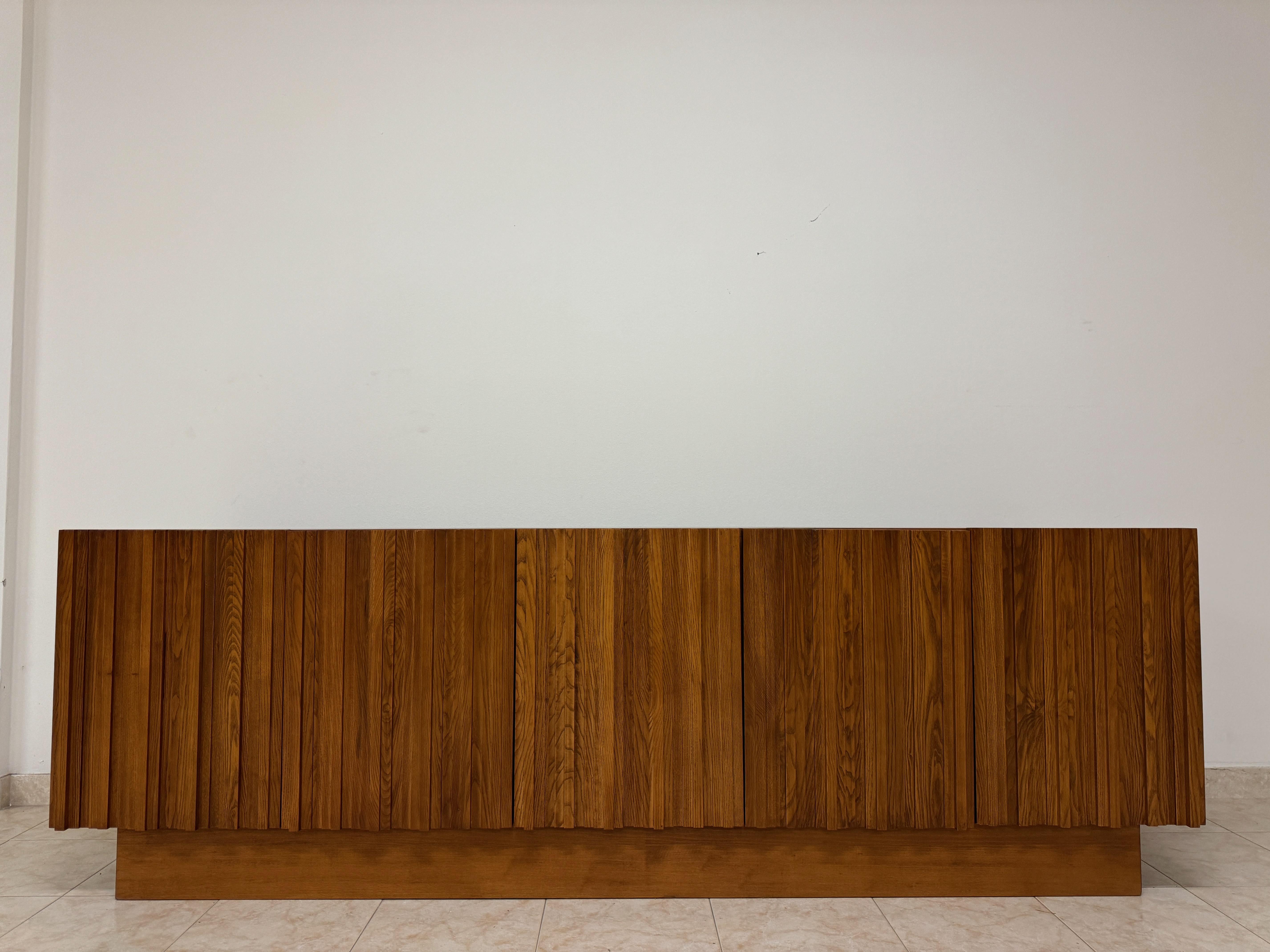 Crédence

Style brutaliste

Cinq portes

Armoires avec étagères

Fabriqué en Italie 

Contemporain

Ce buffet Brutalist contemporain, fabriqué de manière experte en Italie, illustre une esthétique de design audacieuse et robuste. La pièce se