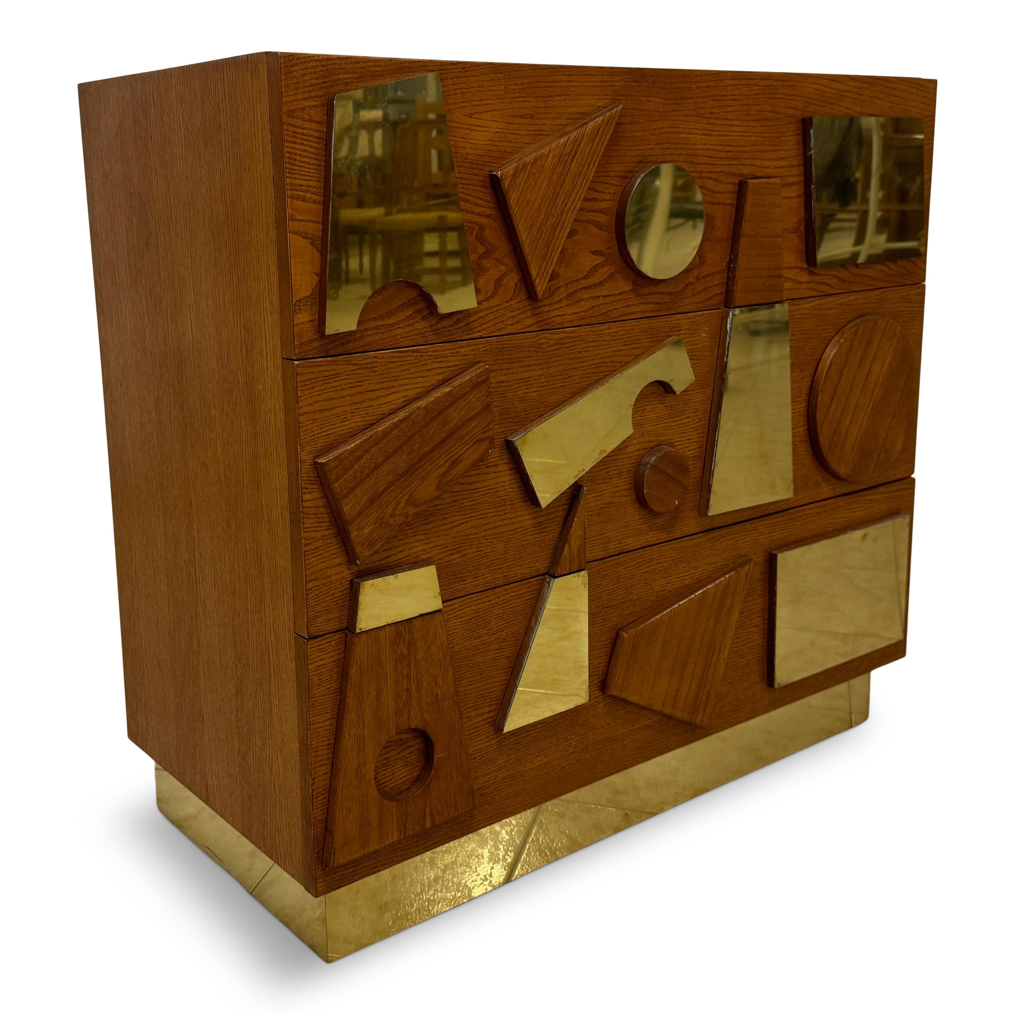 This contemporary chest of drawers is a striking piece that combines functionality with artistic flair. The chest features a clean, rectangular form crafted from rich, warm-toned wood, which gives it a classic yet modern appeal. The standout element