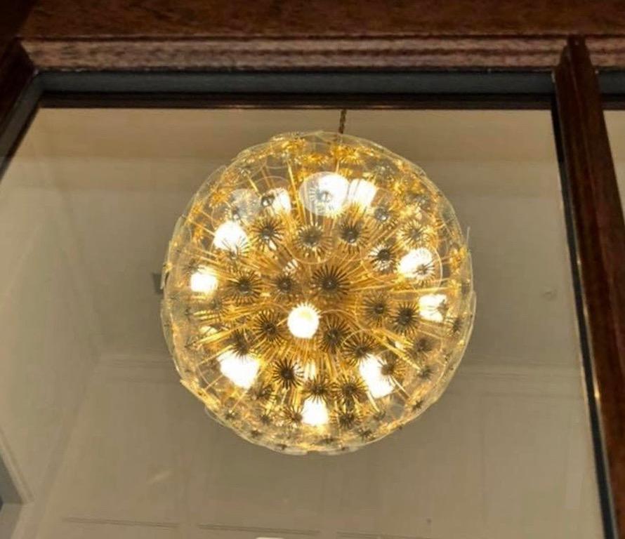 Exclusive Bespoke huge Italian organic chandelier, Work of Art entirely handmade in 1960s Mid-Century Modern style like a dandelion, with many brass stylized flowers having a clear glass core, supported by brass rods jutting out of a central brass