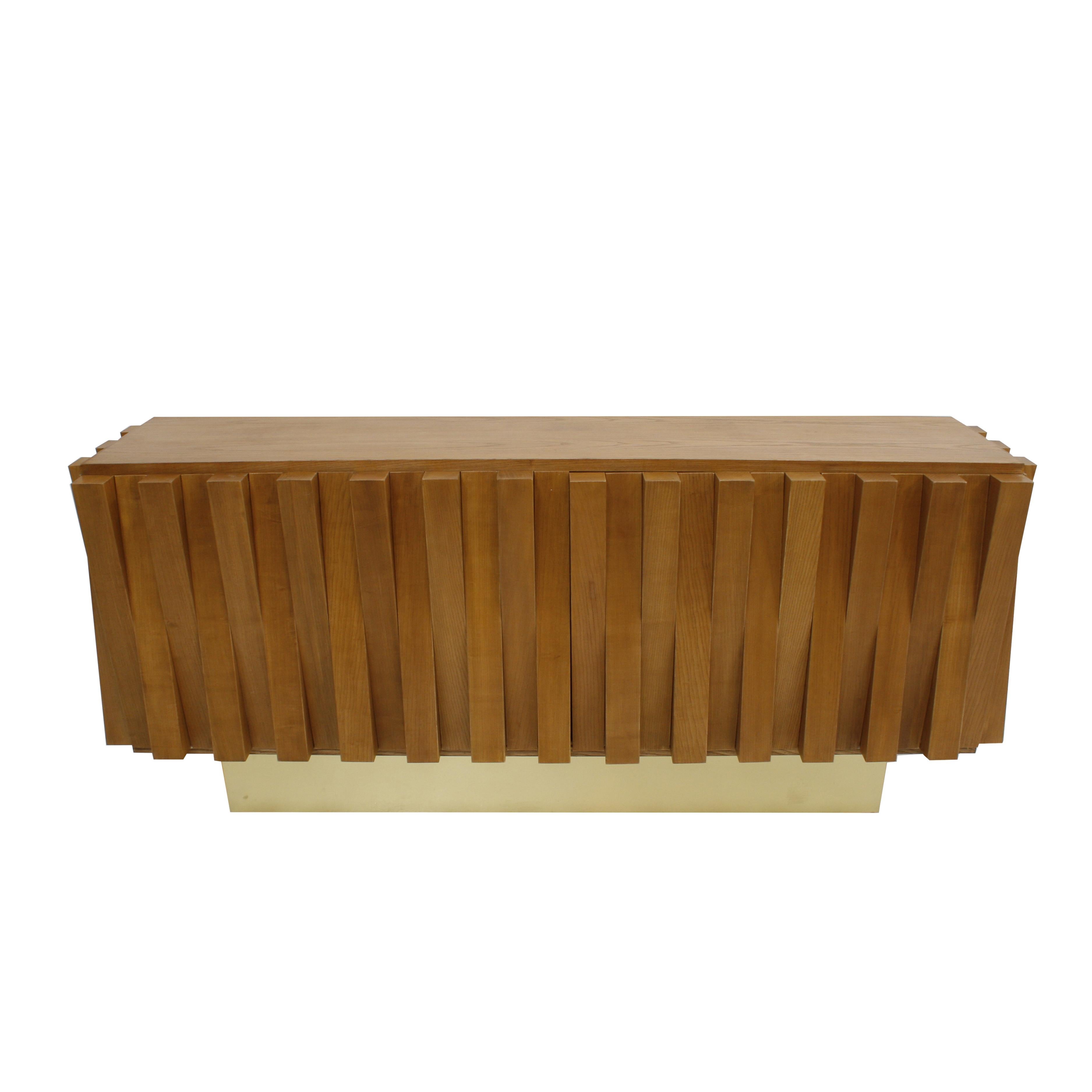 This exquisite faceted dry bar is designed by LA Studio and handcrafted in Italy, combining solid oak with elegant brass accents. The piece features two central sliding doors and two hinged doors at the ends, offering versatile storage for bottles,