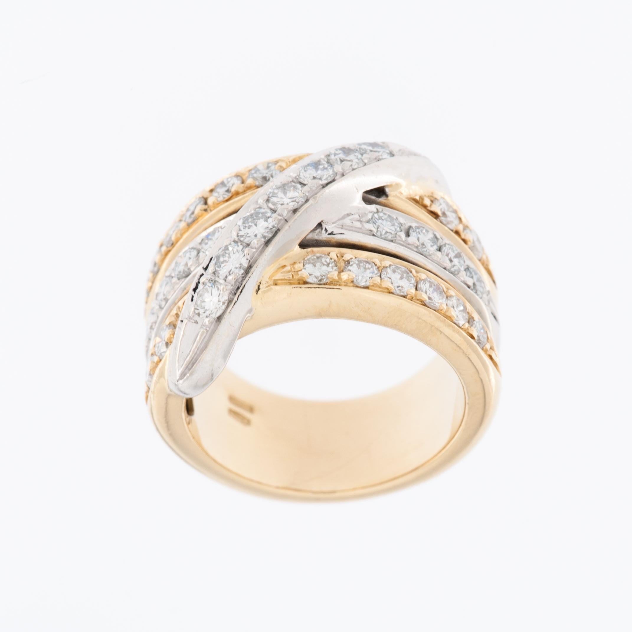 La bague contemporaine en diamant de style italien présente un anneau croisé en or jaune et blanc 18kt avec un sertissage à griffes. Ce design combine deux couleurs d'or différentes, le jaune et le blanc, créant ainsi un look unique et moderne.

Le