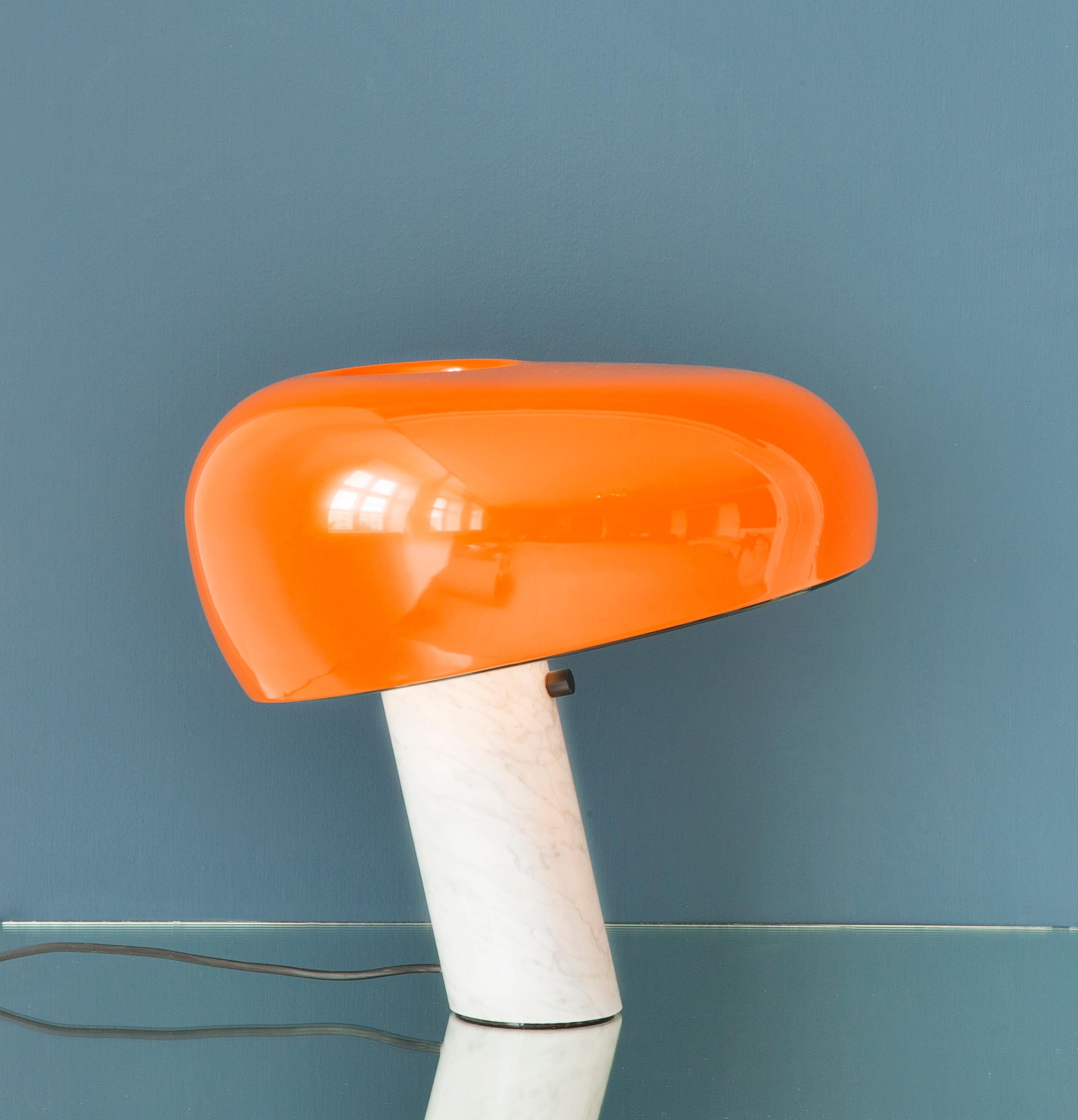 Contemporary Italian Snoopy table lamp from Flos with white marble base and orange lacquered metal shade. Special re-edition made for The Apartment in 2015.

The Italian architect and designer brothers Achille Castiglioni (1918-2002) and Pier