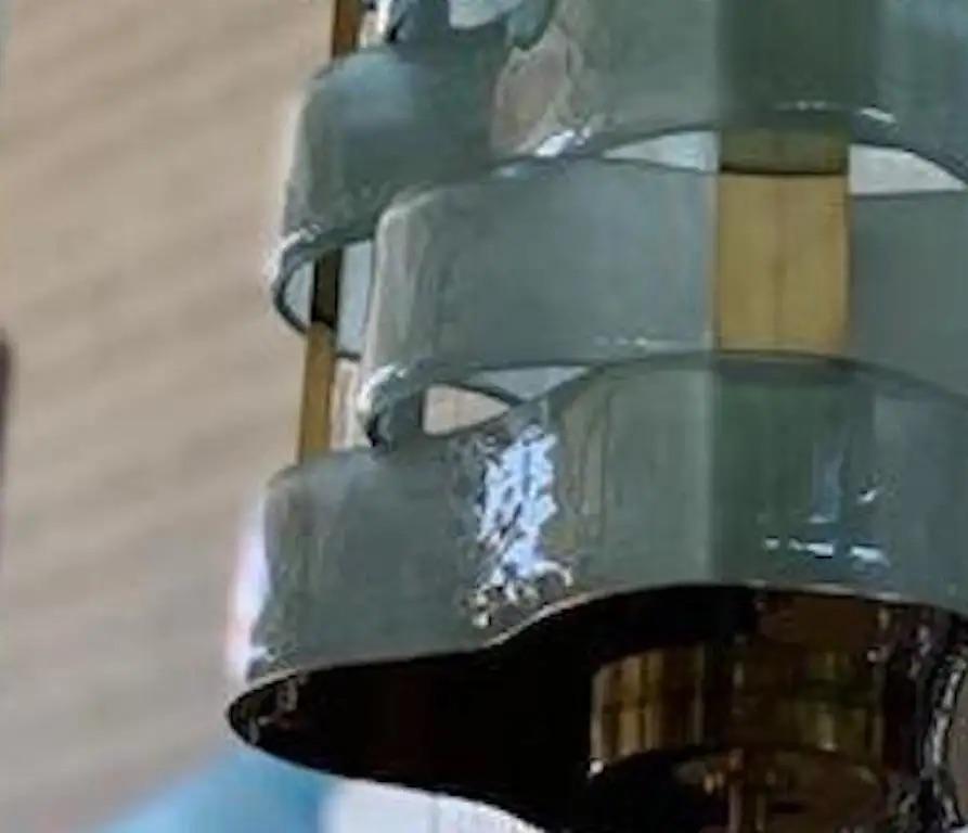 Contemporary organic modern light fixture, entirely handcrafted in Italy, the brass structure supports nature-inspired airy weaving blue teal aquamarine elements resembling sea waves in blown textured frosted Murano glass with a traditional Fontana