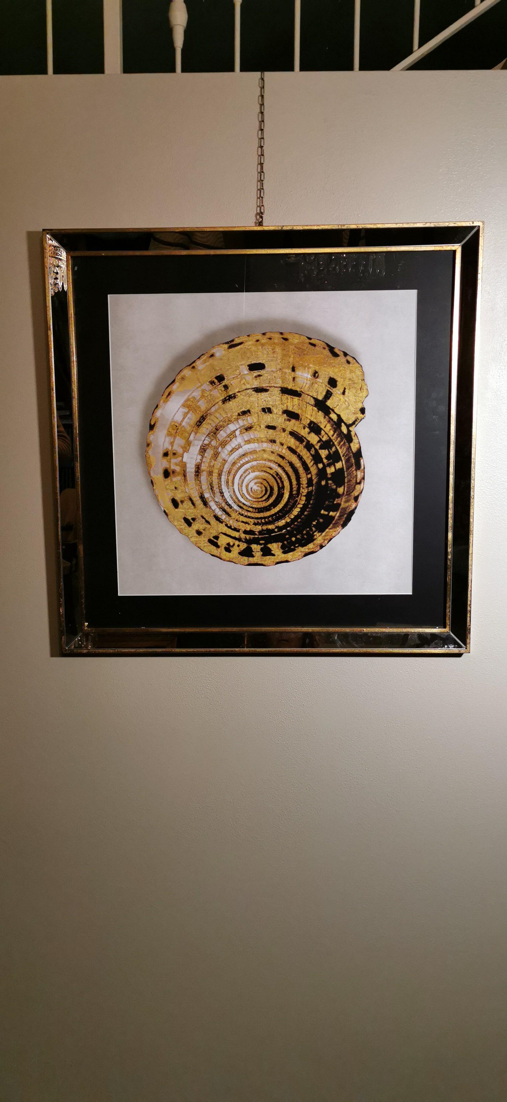 Elegant hand-colored print representing a golden shell. The handcrafted frame is in gilded wood with mirror inserts. This print is made with a special technique called giclée. The giclée printing technique is an individual high definition