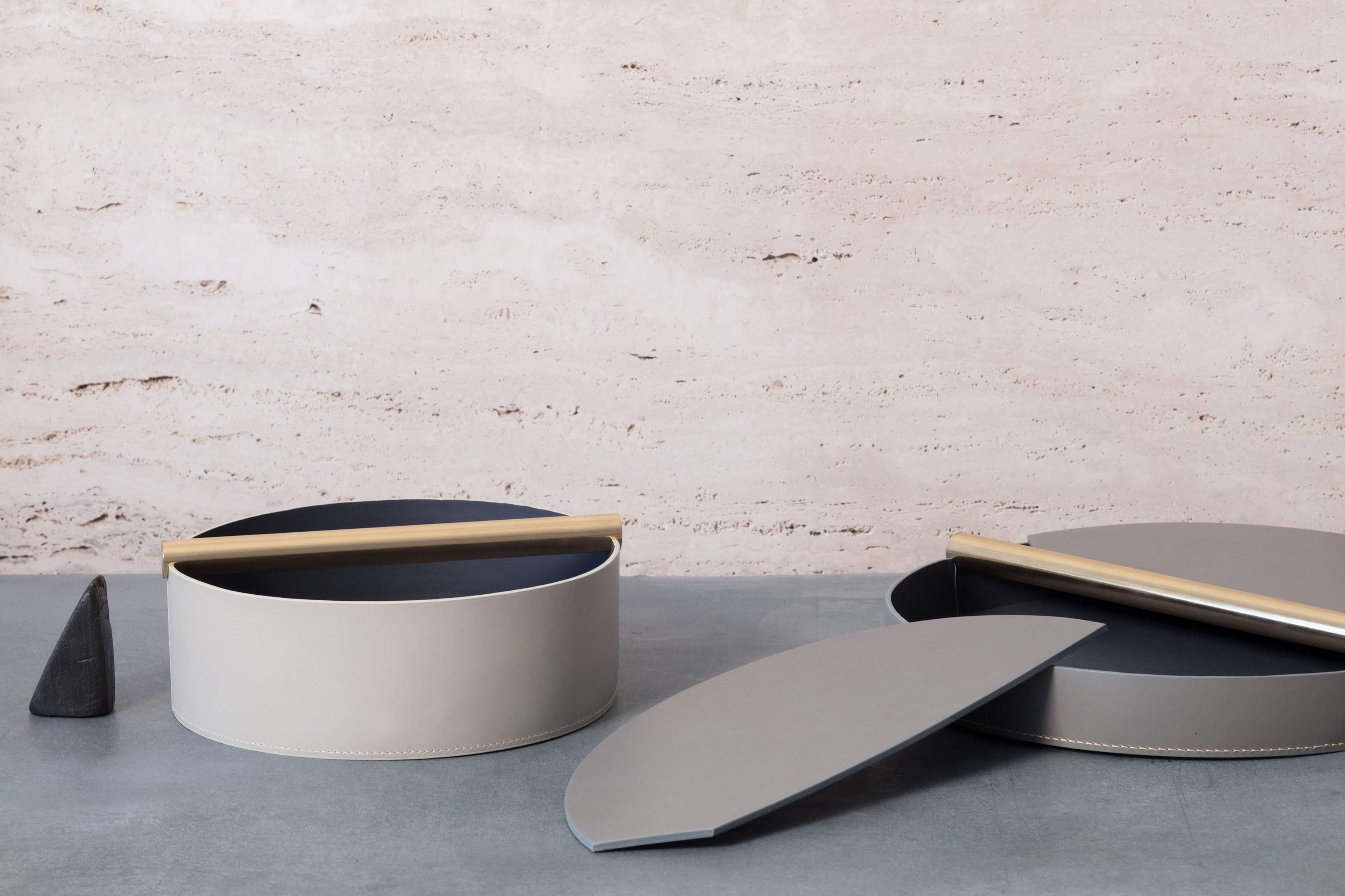 Part of Les Few's Julie collection, this contemporary, round, leather and brass, modern, minimalist centerpiece tray is made by artisans in Sweden. The leather centerpiece tray can be made in several color options with a polished lacquered brass