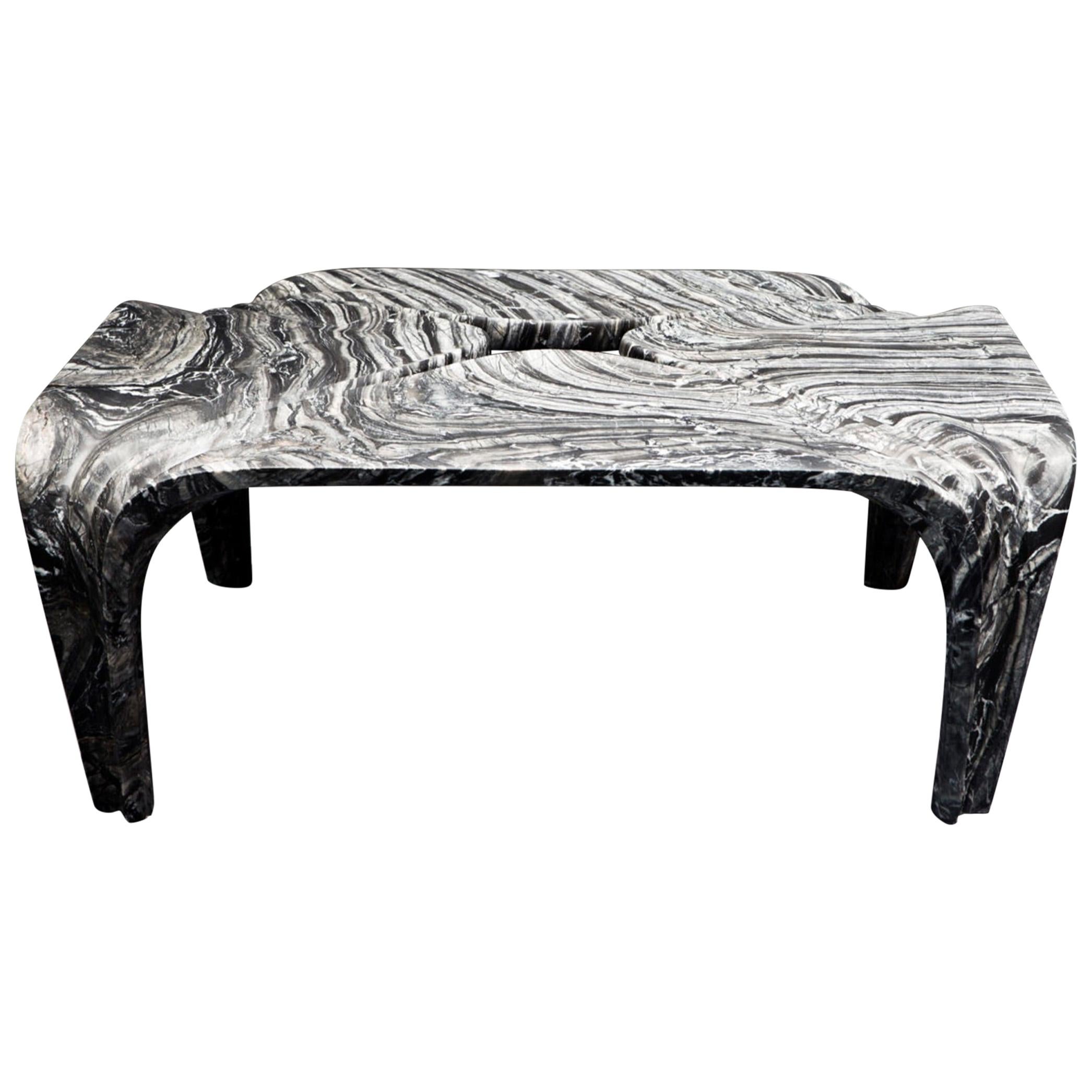 This Italian marble table is formed from triangular quadrants of marble that join at the corners and curve down to form the legs. The inside corners have a rounded finish, creating gaps in the center of each tabletop. The surface of the marble is