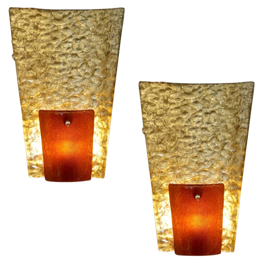 Modernist geometric pair of gold and amber/orange Murano glass wall lights, entirely handcrafted in Italy. A very interesting part is the thin backplate (1.5